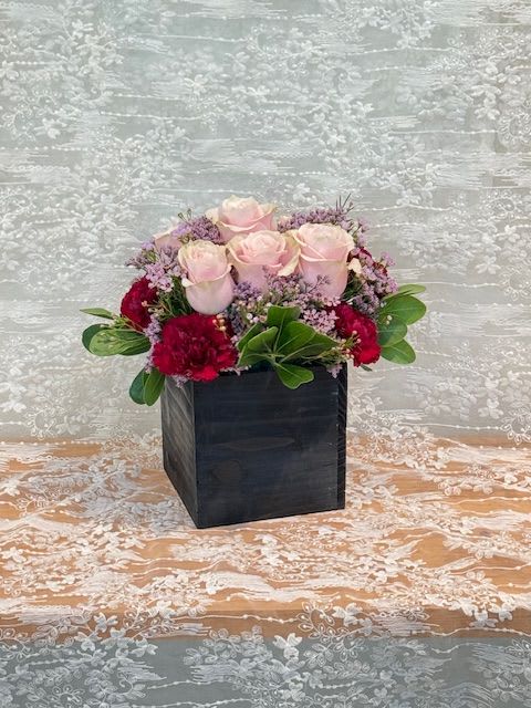 Bloom in a box - Light pink roses, lavender wax flower and burgundy carnations in a black wood box.   If a particular flower, is unavailable, an item of similar quality and value will be substituted