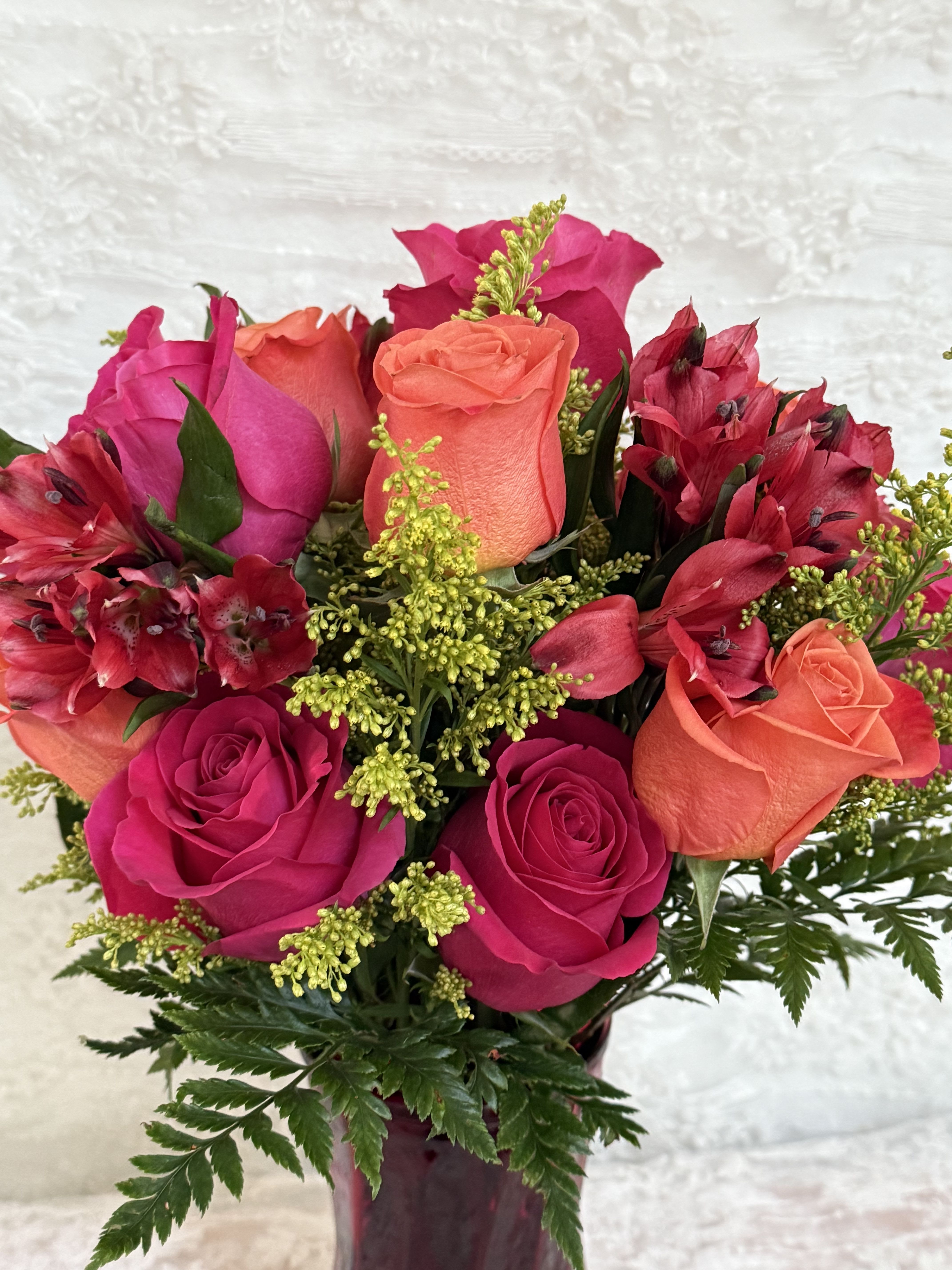 Feliz Cumpleanos  - Bright Birthday celebration  Arrangement of hot pink roses and orange roses tied together with red Alstroemeria and green solidago