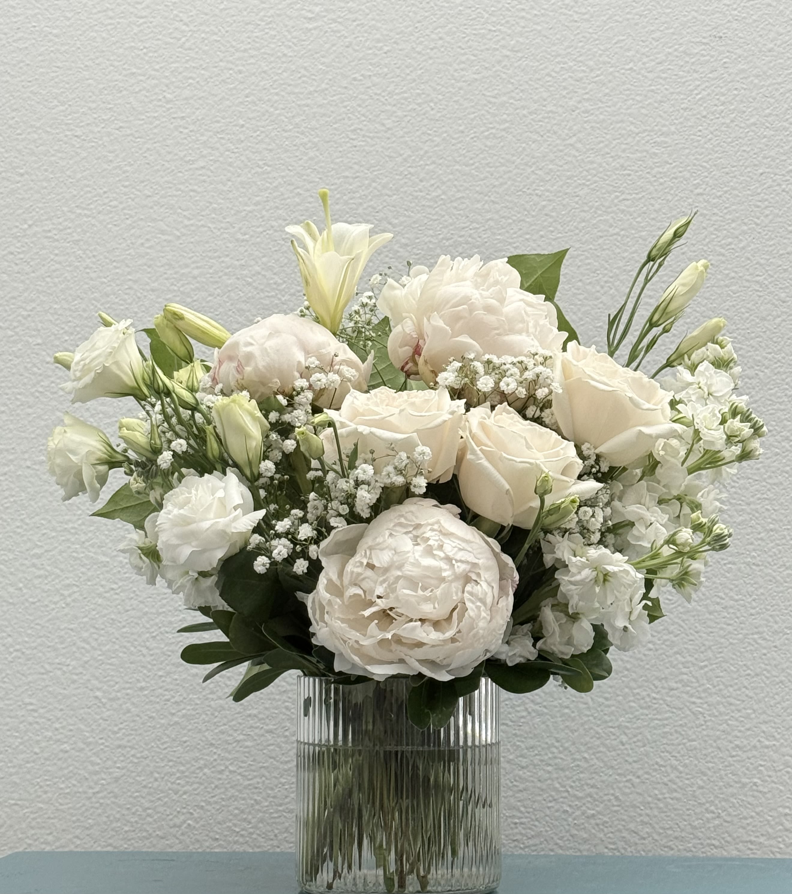 Winter - White arrangement filled with roses, stock flower, peony and lisianthus.  