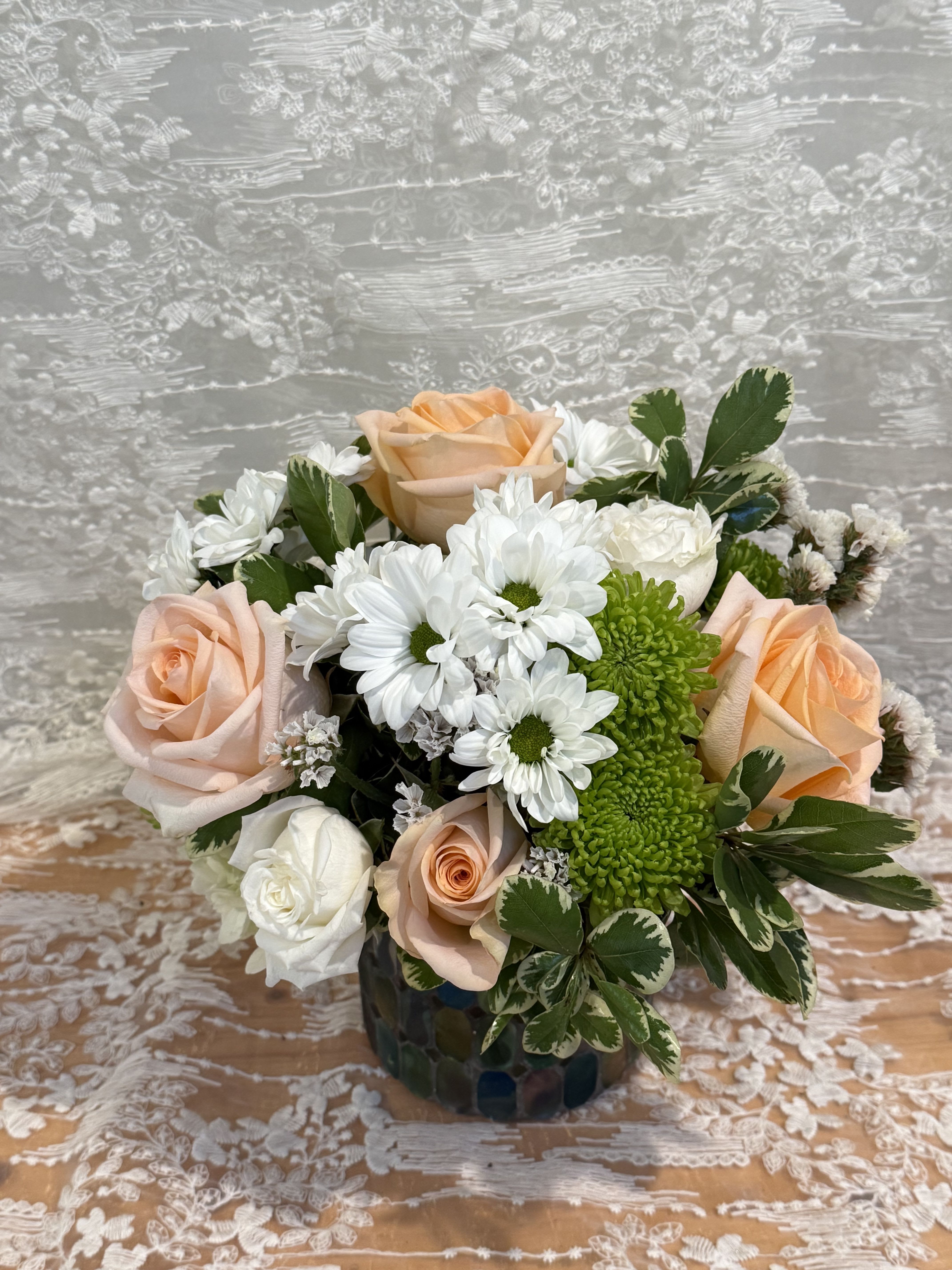 Bee Peachy - Short arrangement Peach roses, mums, and baby white roses in a green mosaic glass vase