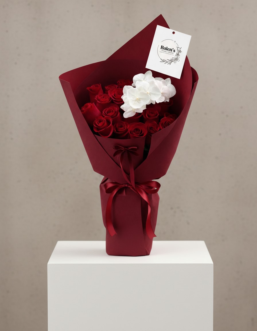 Bouquet of red roses with white orchids wrapped in burgundy paper