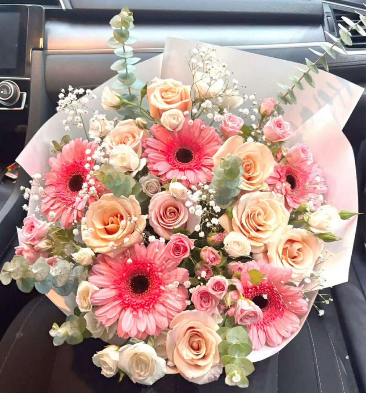 Pink Champagne Bouquet  - A beautiful blend of creamy peach, dusty rose, and brilliant pink blooms, accented with delicate baby's breath and fresh eucalyptus. This sophisticated arrangement is reminiscent of a sparkling glass of bubbly.