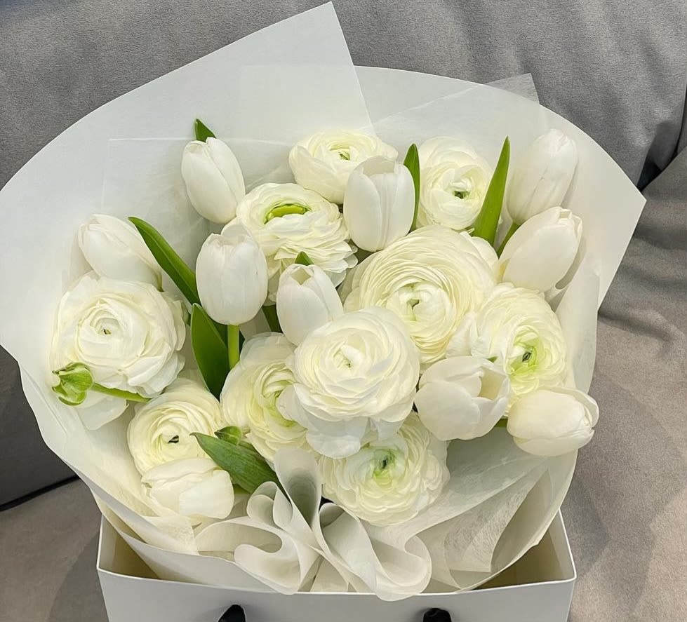 White tulips and ranunculus in white wrapping paper