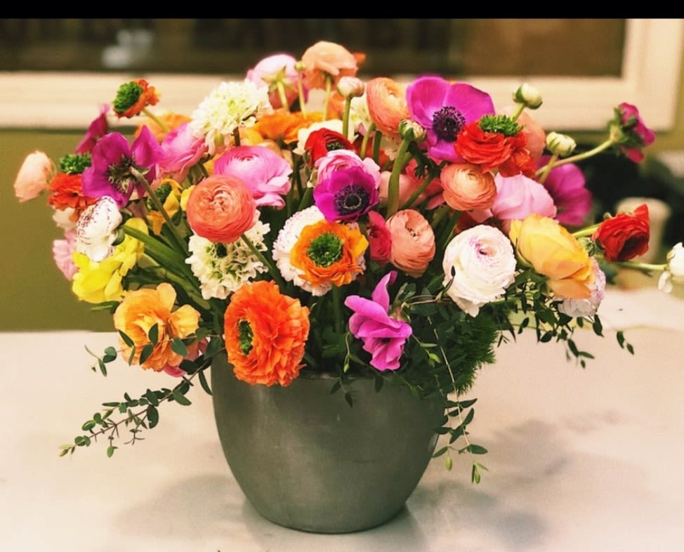 Colorful mixed flower arrangement in a green vase