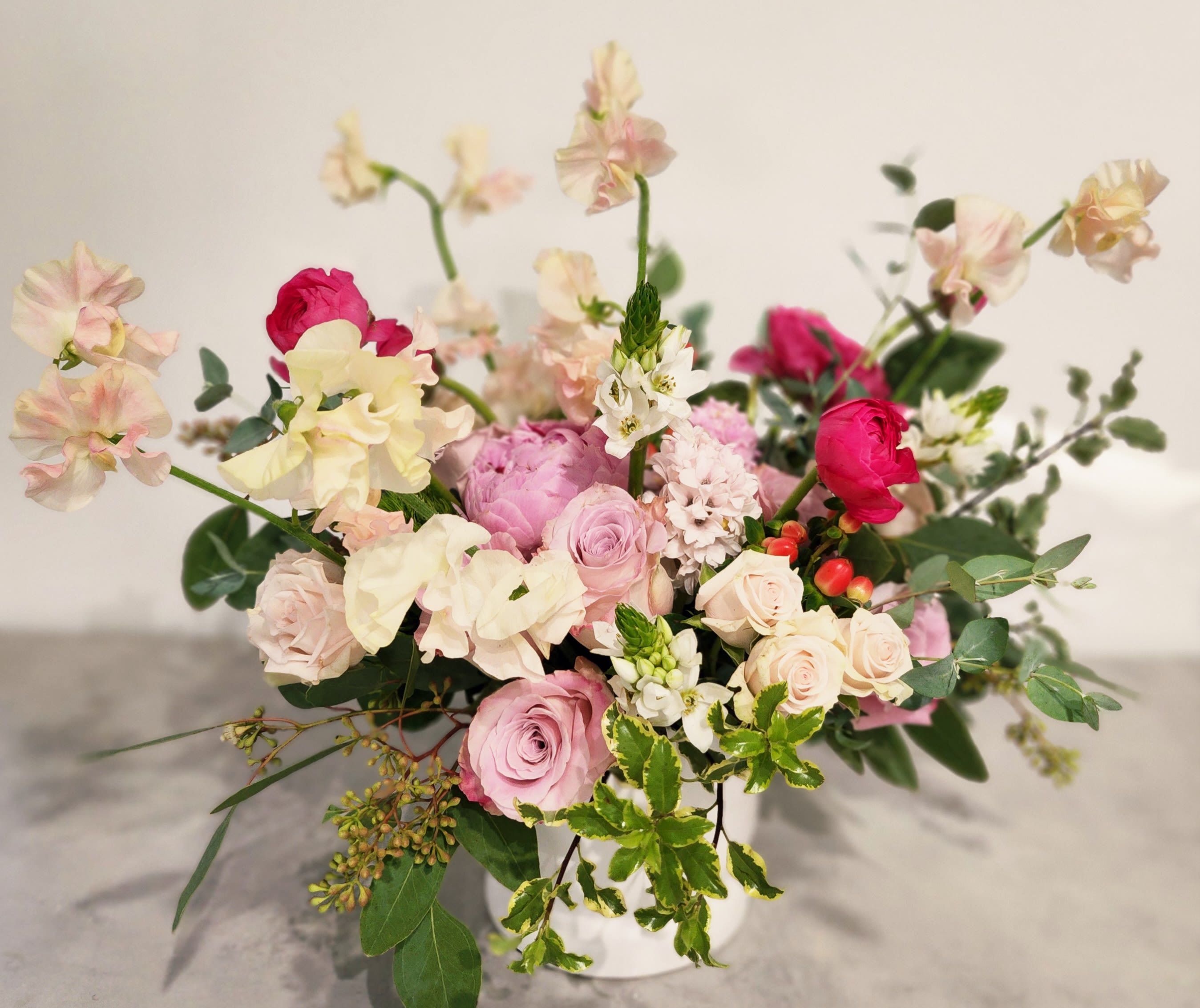 Pink and cream floral arrangement in a white vase