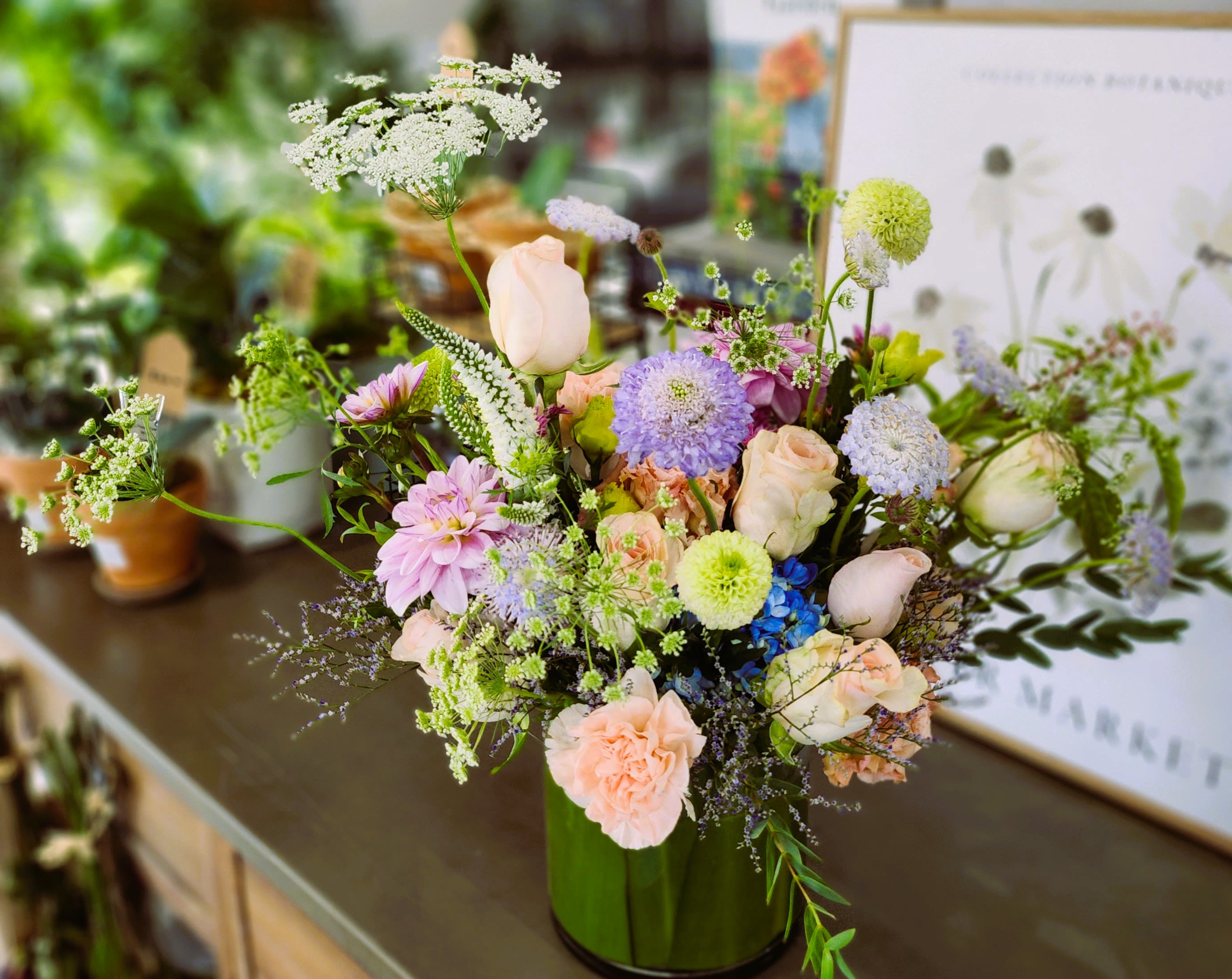 Pastel mixed flower arrangement in a green vase