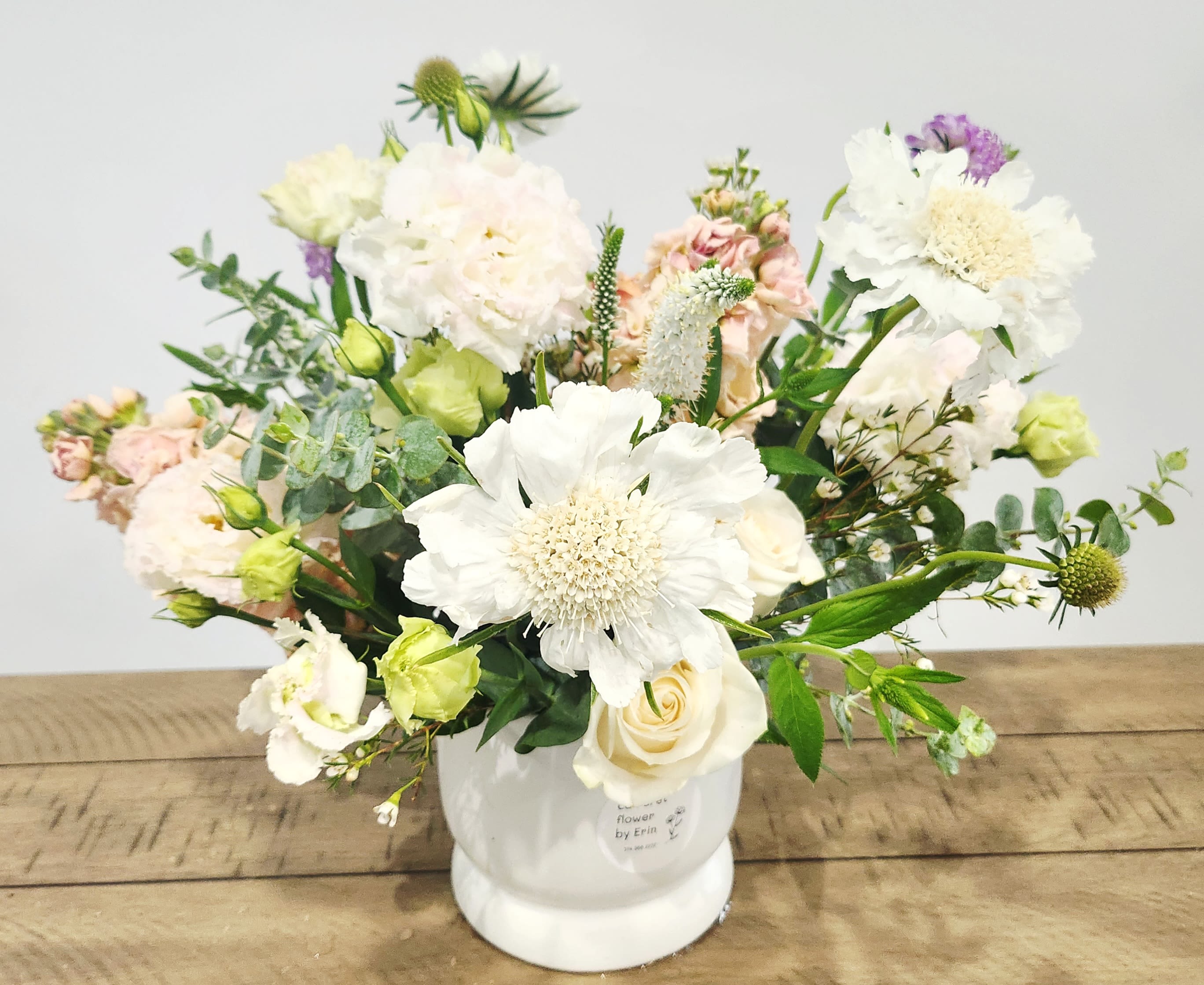 White and blush mixed flower arrangement in a white vase