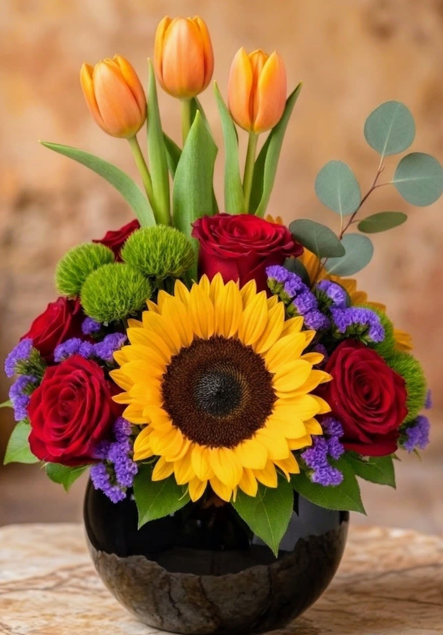 Sunflower, Roses &amp; Tulips Arrangement – Same Day Delivery San Antonio - Beautiful sunflower and rose arrangement in San Antonio by Snyder Flowers featuring fresh sunflowers, red roses, orange tulips, green button mums and seasonal greenery designed in a modern glass vase perfect for Mother’s Day, birthdays, congratulations and special occasions with same day flower delivery in San Antonio, premium quality fresh flowers and affordable prices that bring joy and vibrant color to every gift