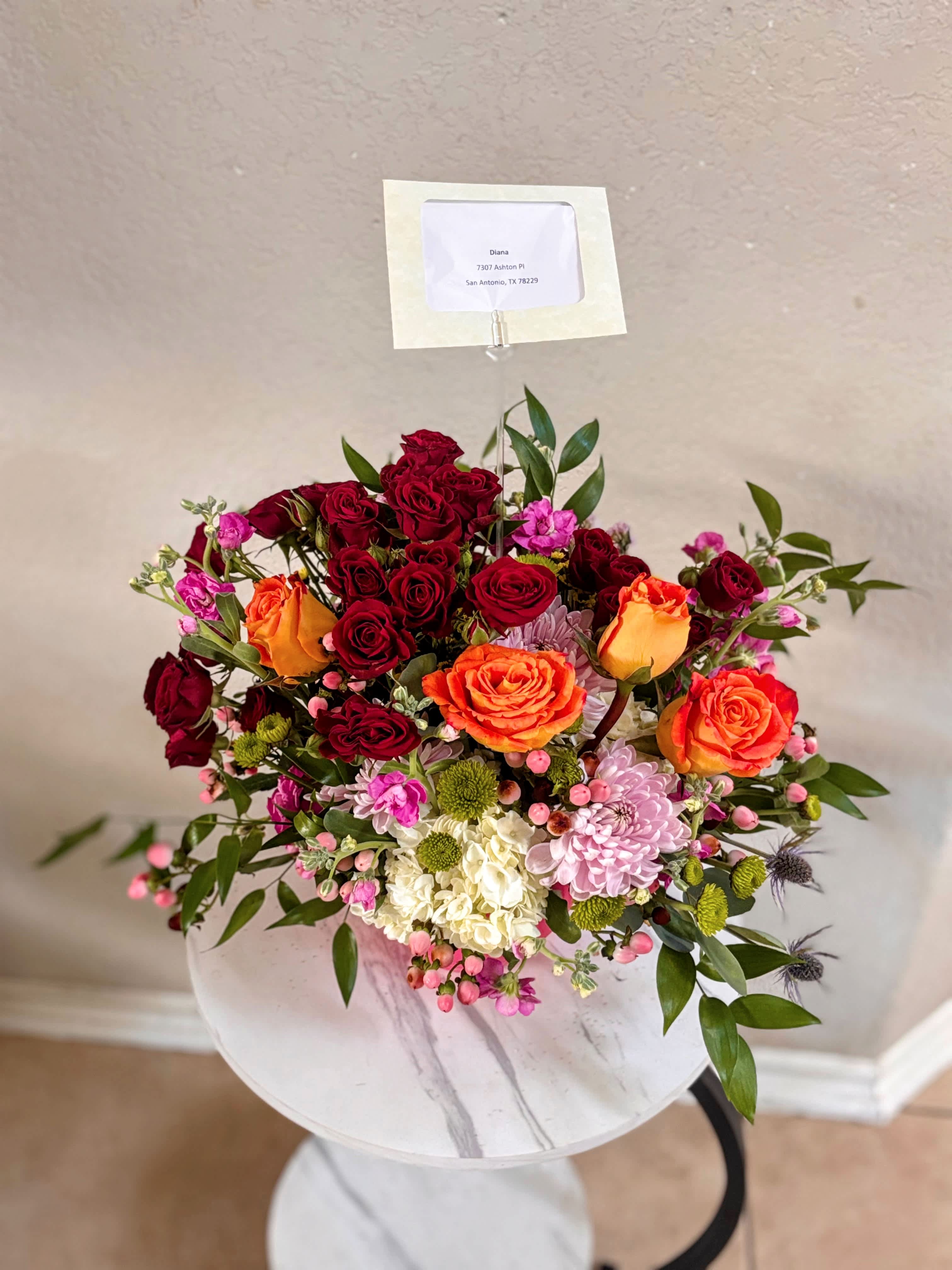 Mixed bouquet of red and orange roses with pink and white flowers