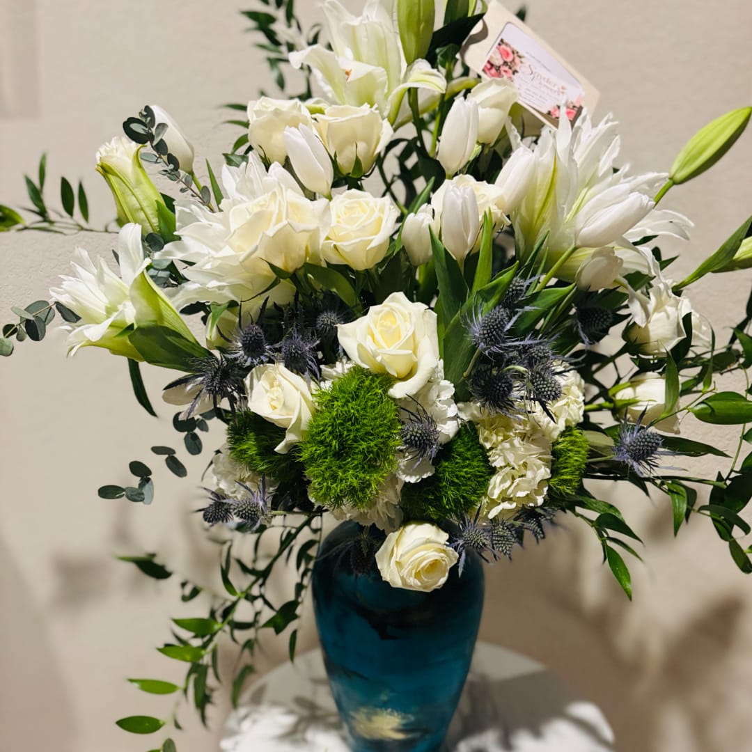 White roses and lilies arranged in a blue vase