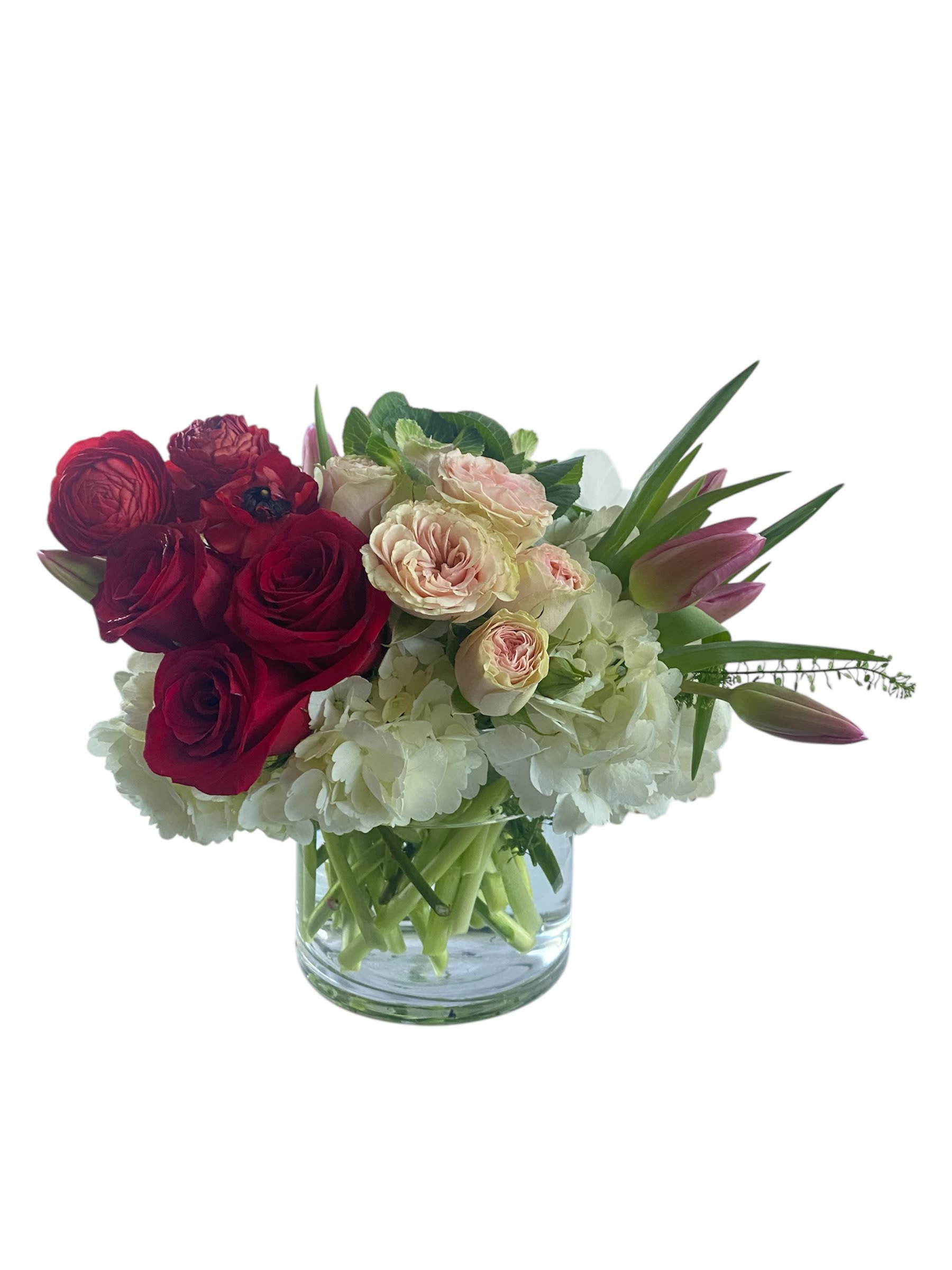 Bouquet of red and blush roses with white hydrangeas in a glass vase