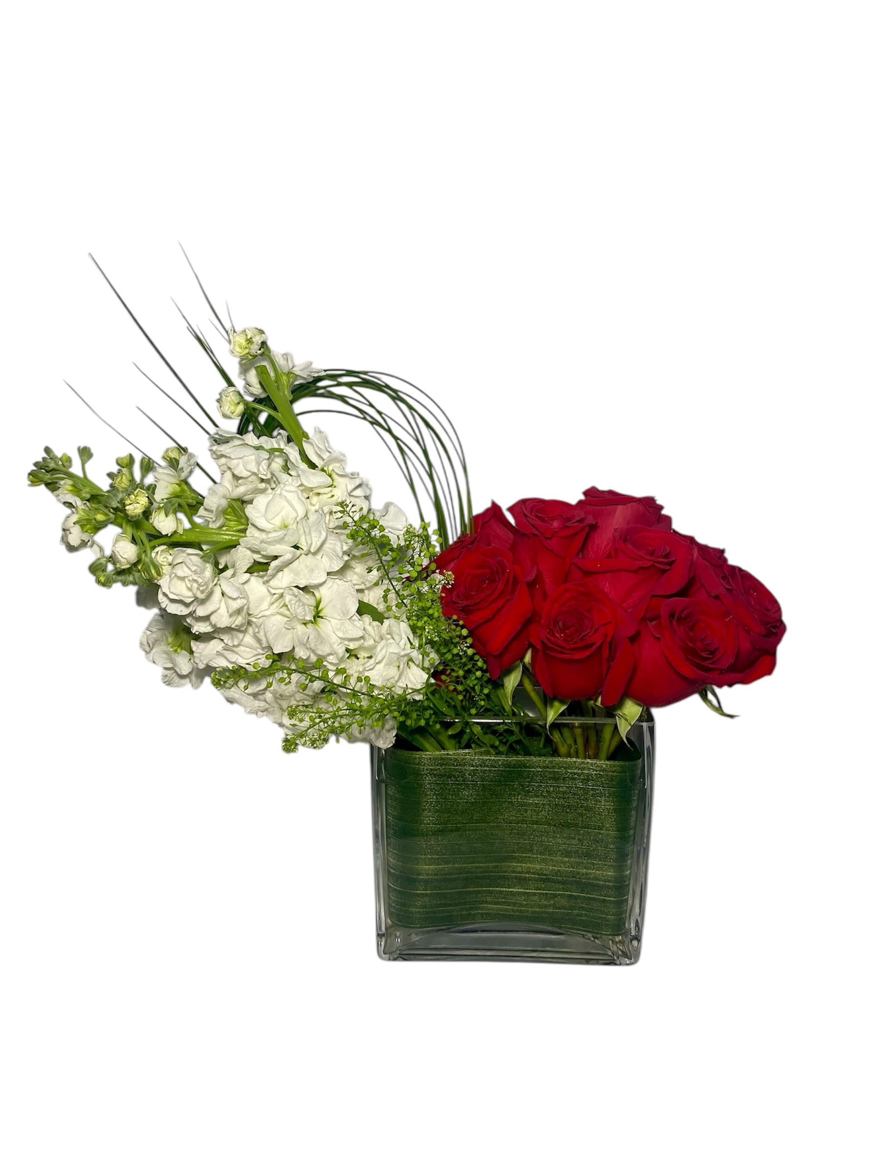 Red roses and white flowers in a square glass vase