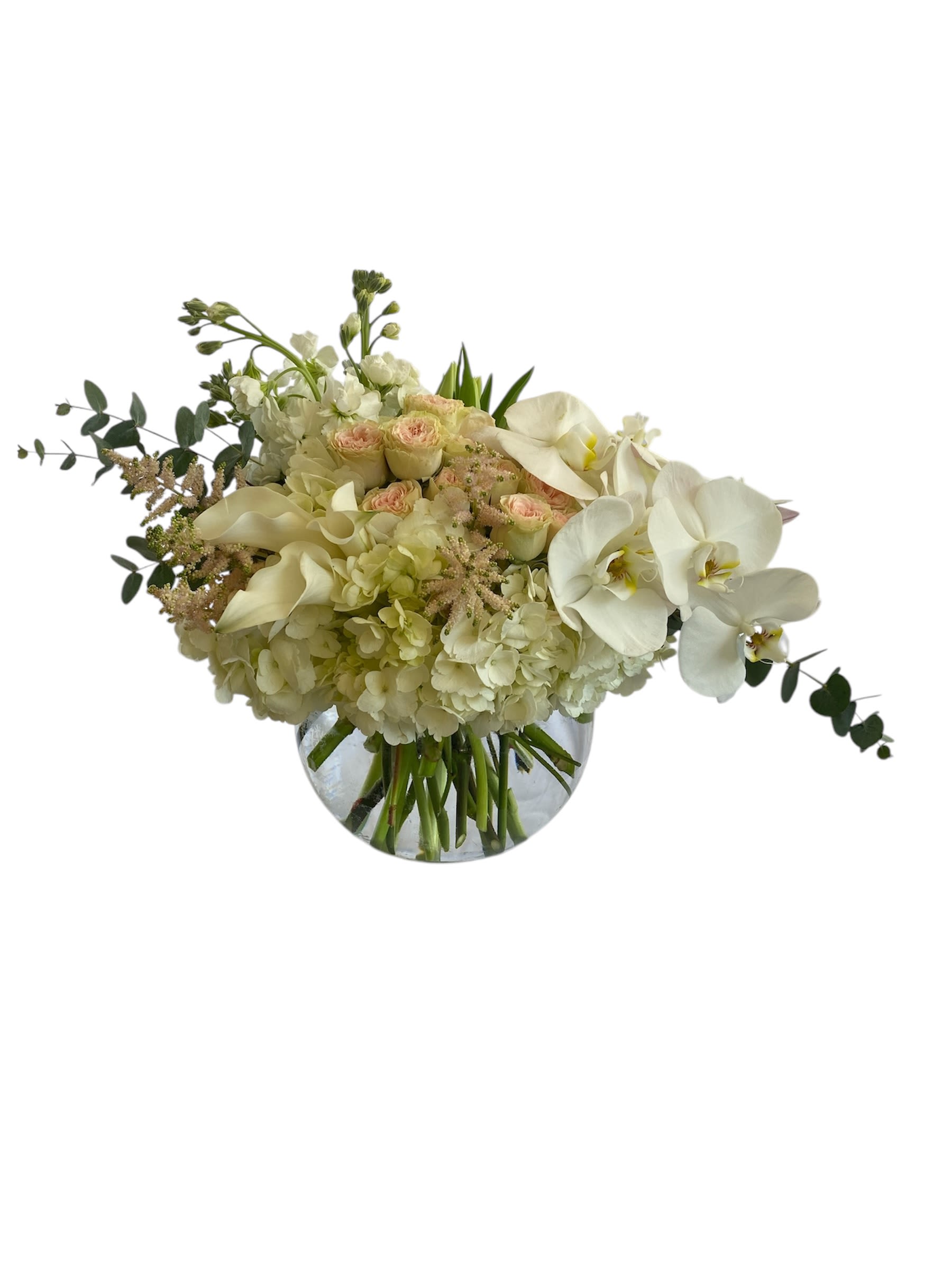 White floral arrangement in a round glass vase with orchids and hydrangeas