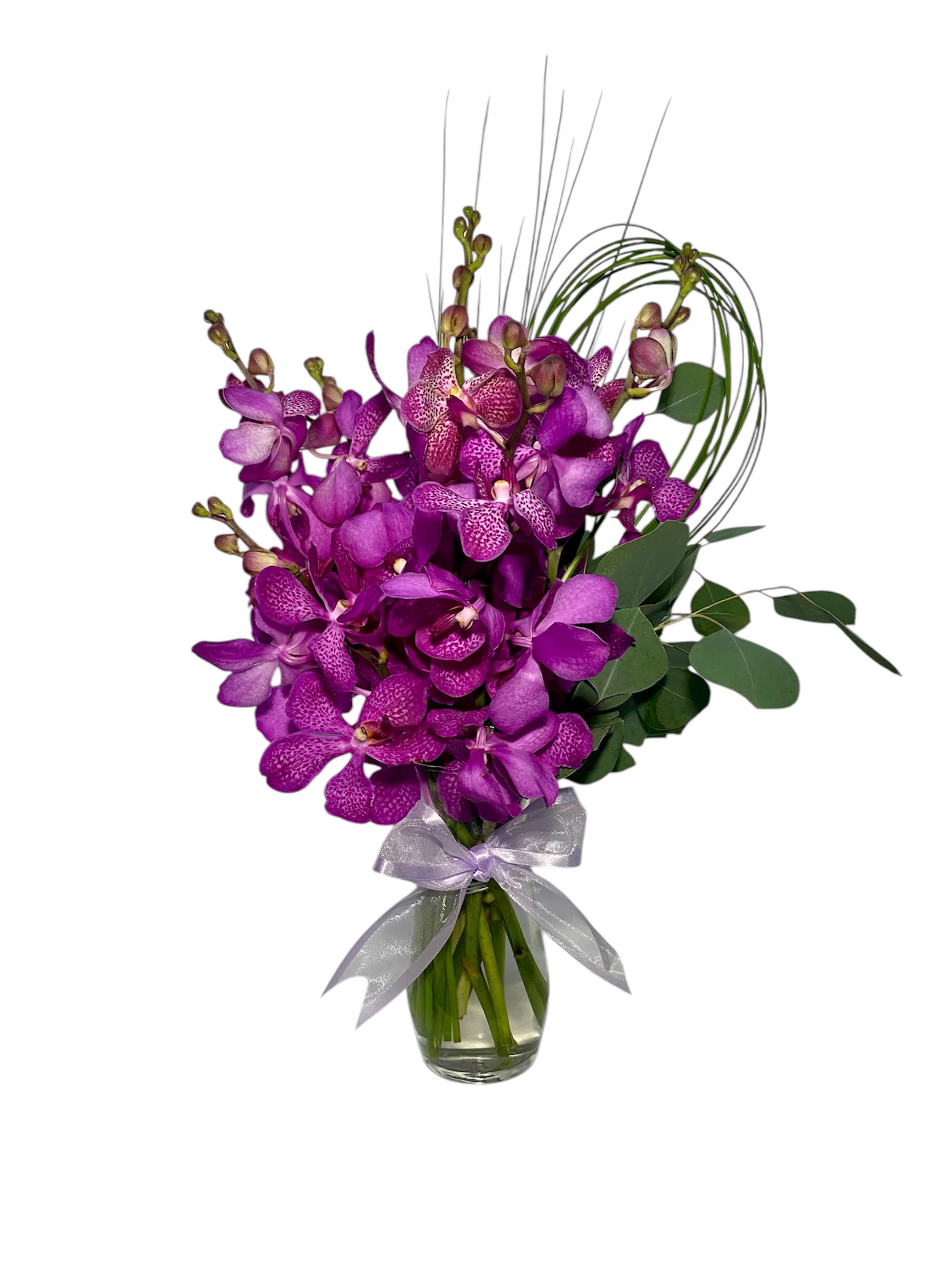 Purple orchids in a clear glass vase with a silver ribbon