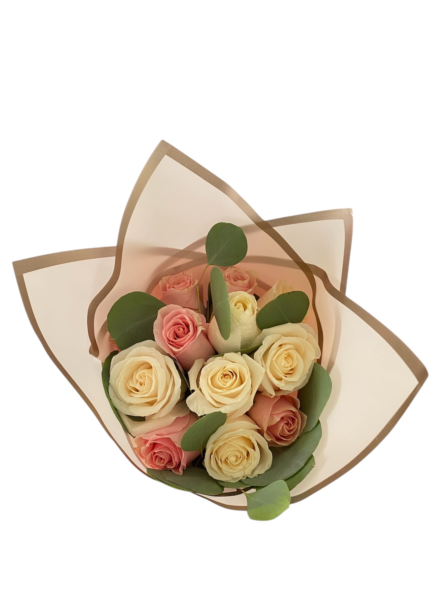 Bouquet of pink and cream roses wrapped in translucent paper