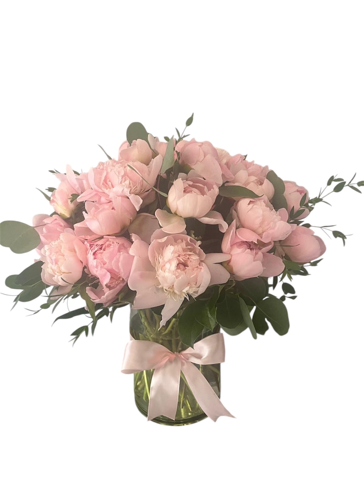 Pink peonies in a glass vase with a pale ribbon