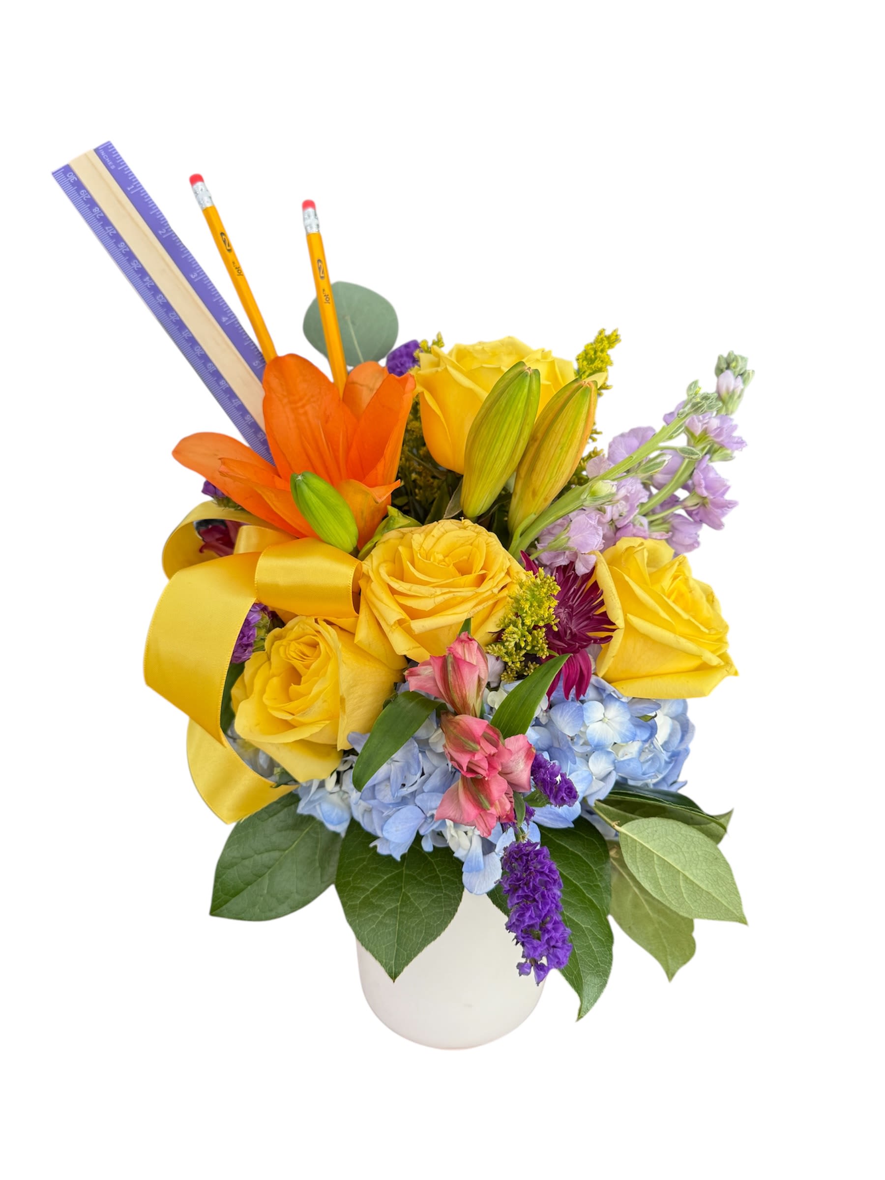 Yellow roses and mixed flowers in a white vase with pencils and rulers