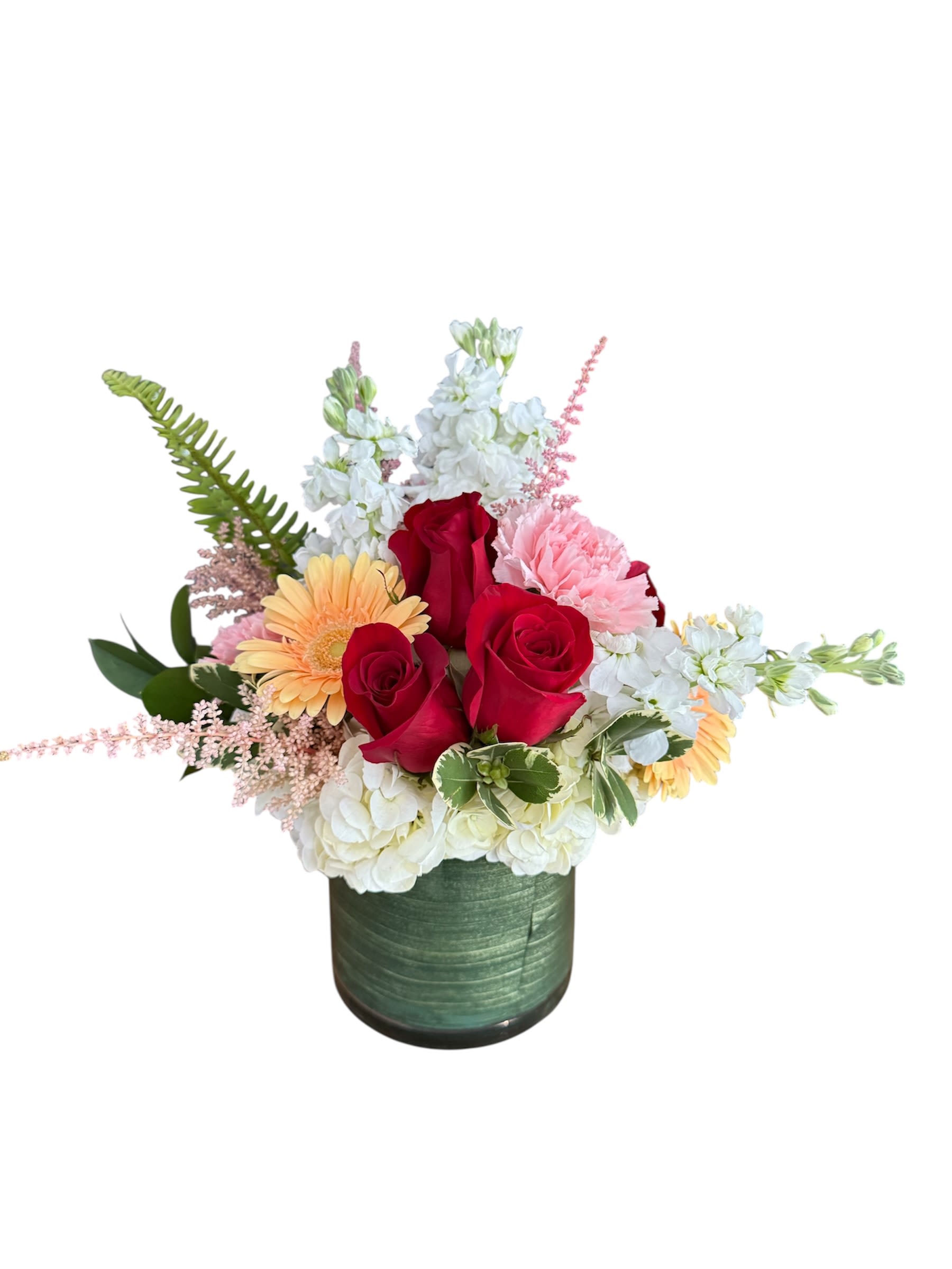 Mixed bouquet of red roses, white blooms, and pink flowers in a green vase