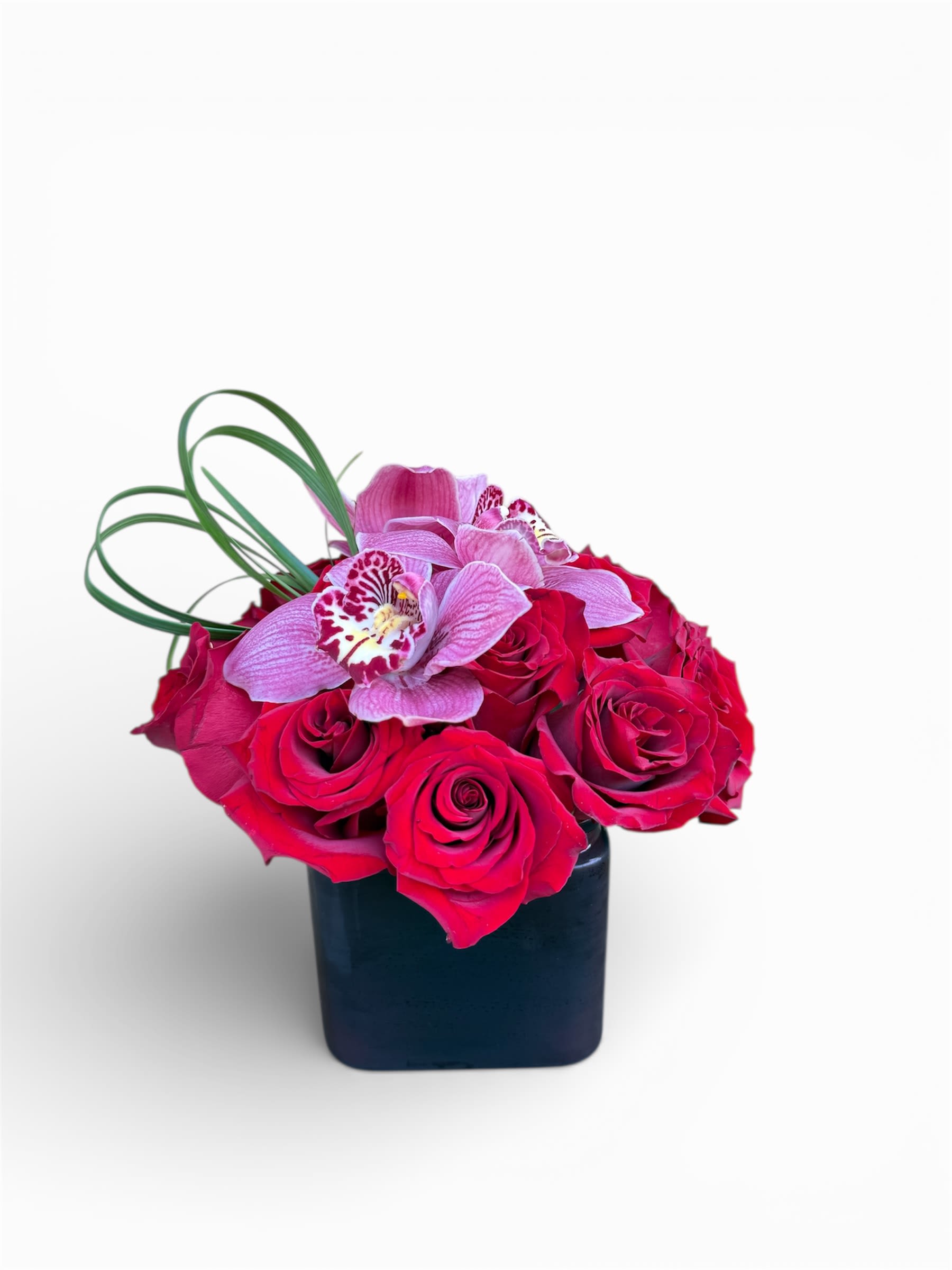Pink roses and orchids in a black square vase