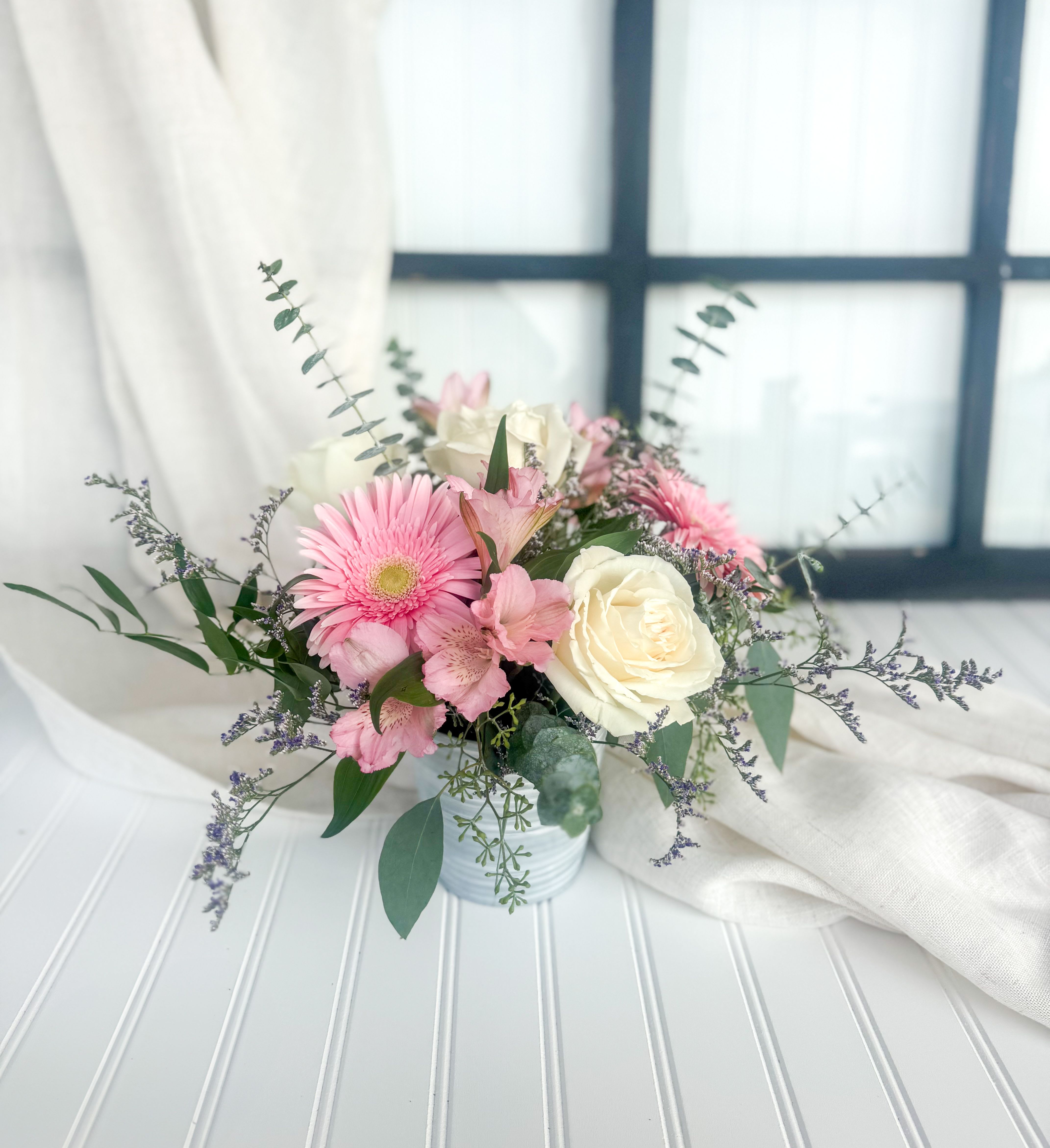 Pink and white bouquet in a small white vase