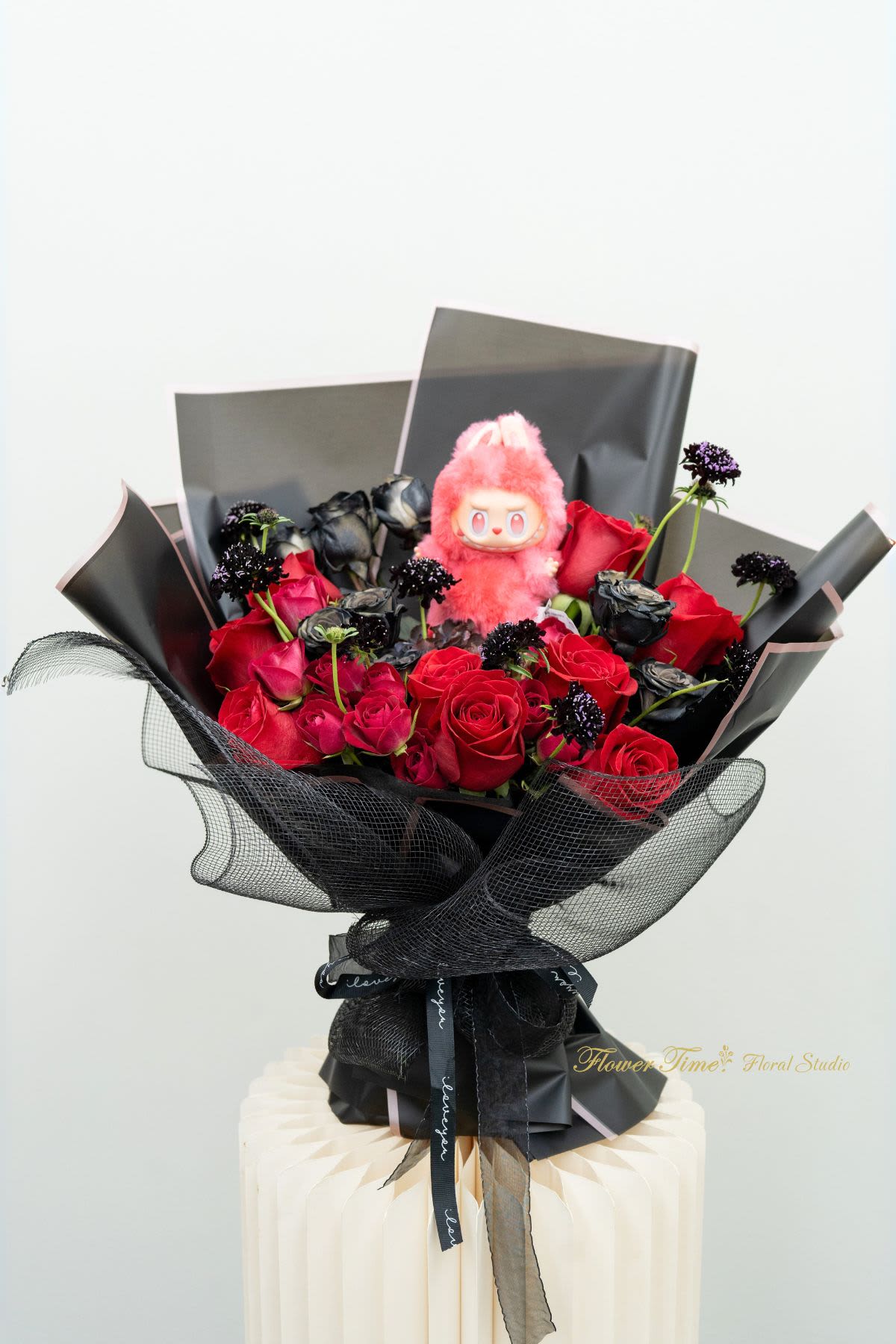 Bouquet of red and black roses with a pink plush toy