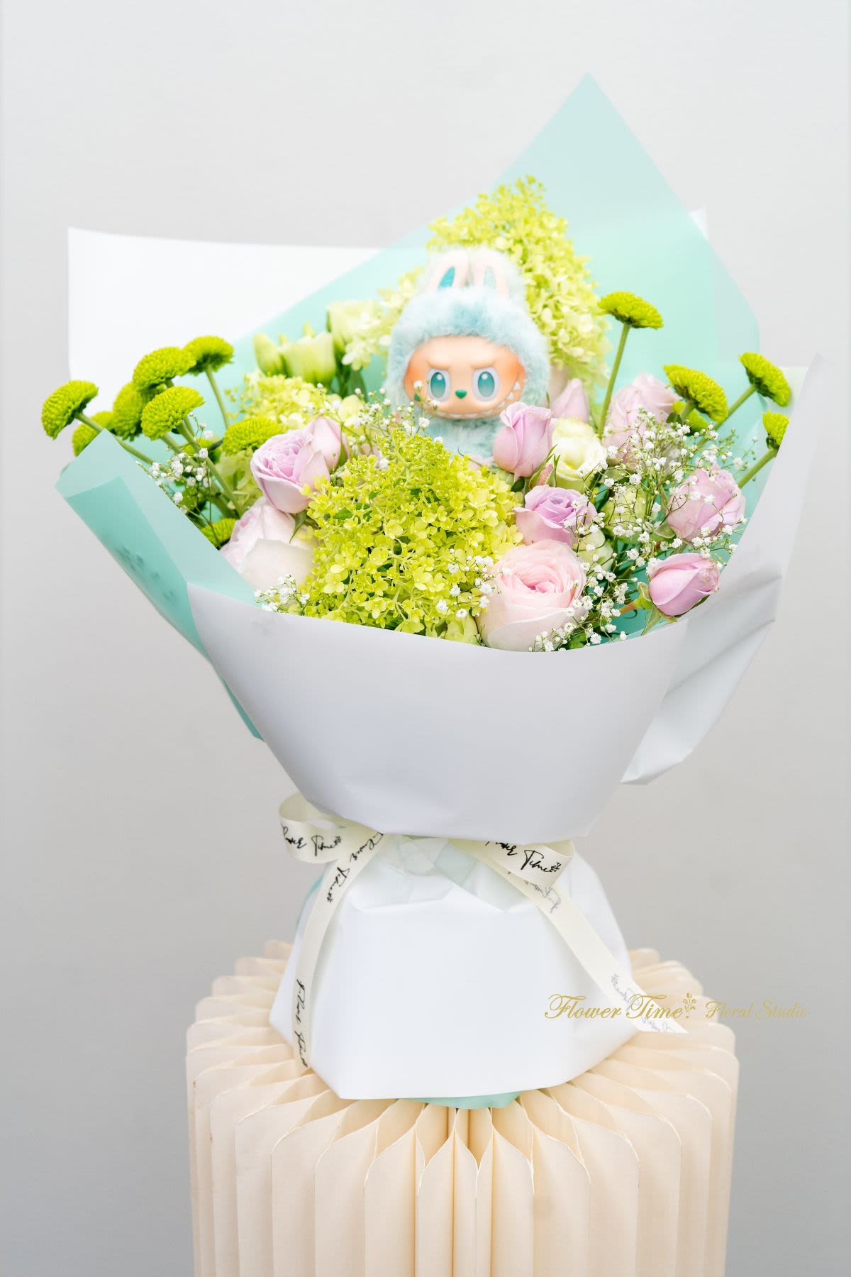 Bouquet of pink roses and green button mums with a plush toy centerpiece