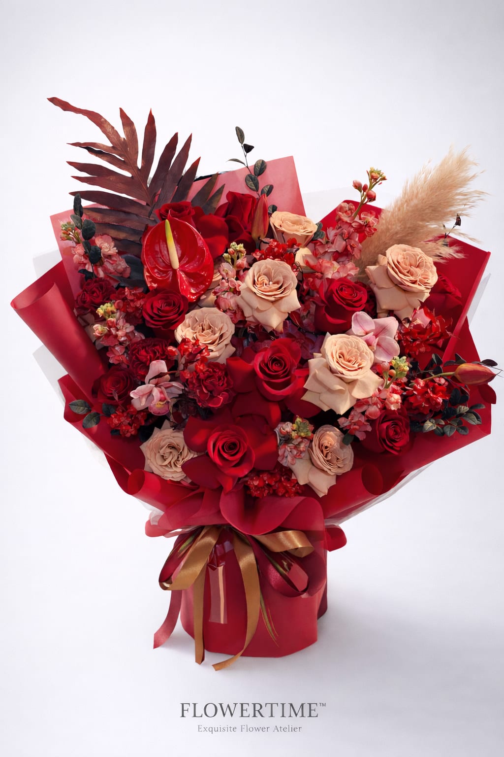 Bouquet of red and blush roses with red wrapping and ribbon