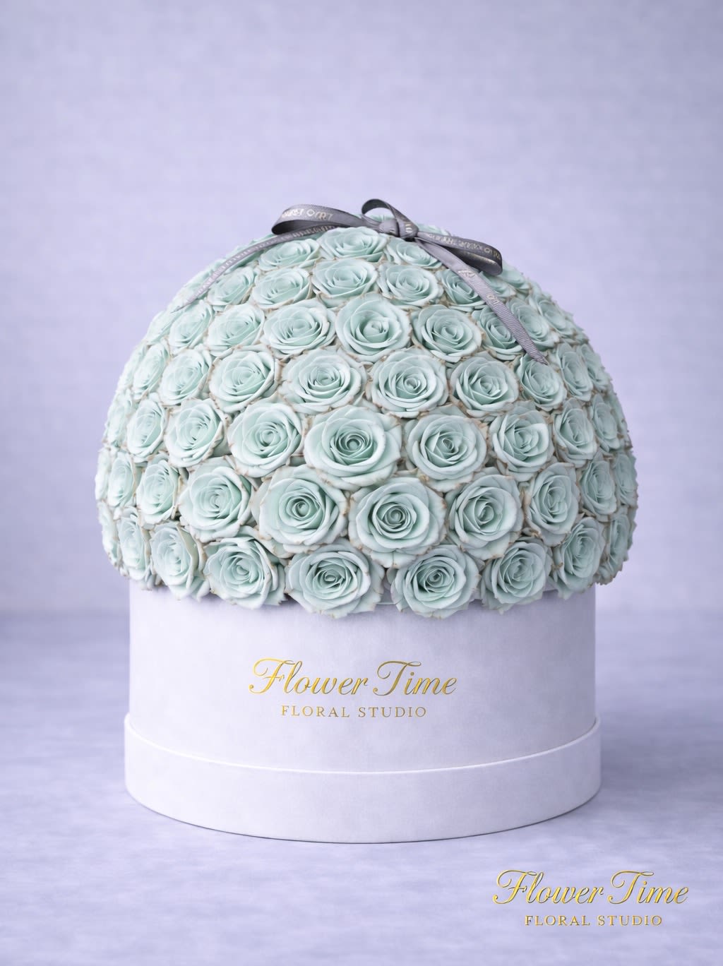 Round box of pale blue roses with a ribbon bow