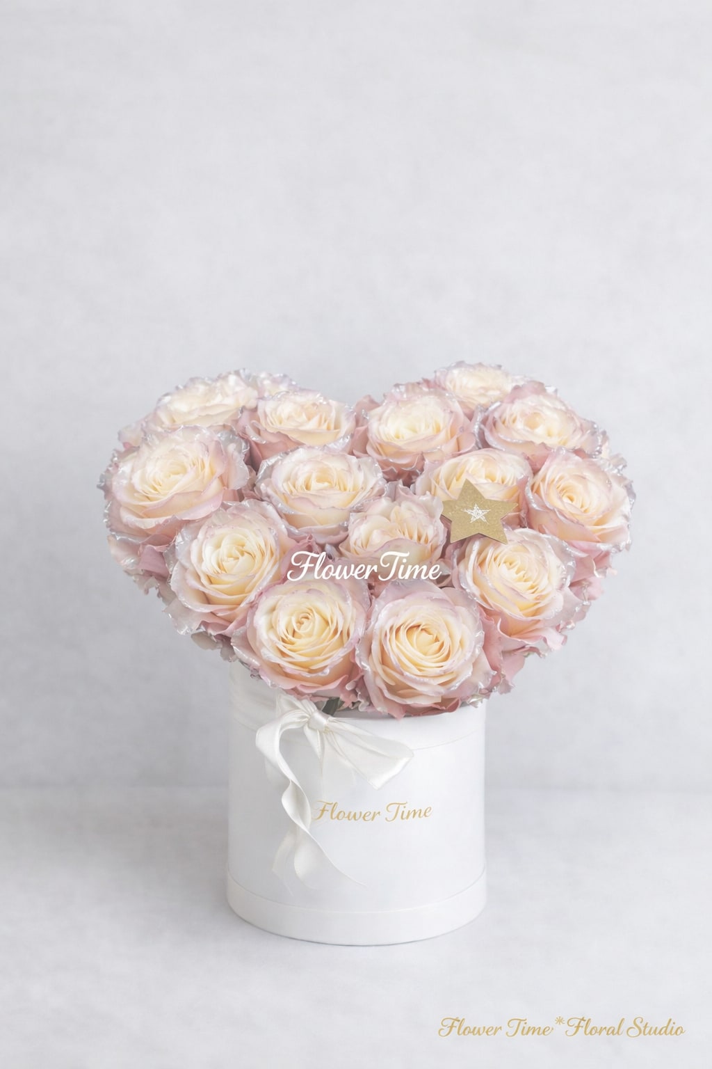 Heart-shaped bouquet of pale pink roses in a white box