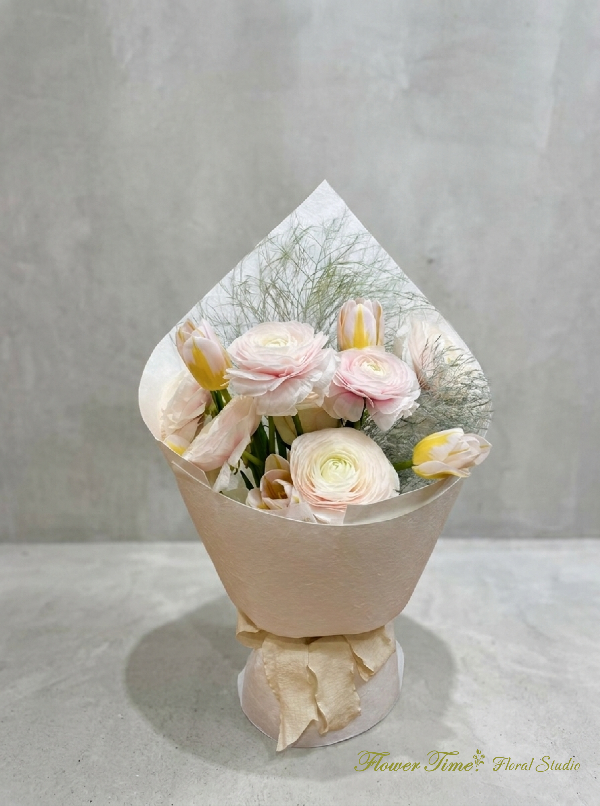 Bouquet of pale pink and white flowers wrapped in beige paper