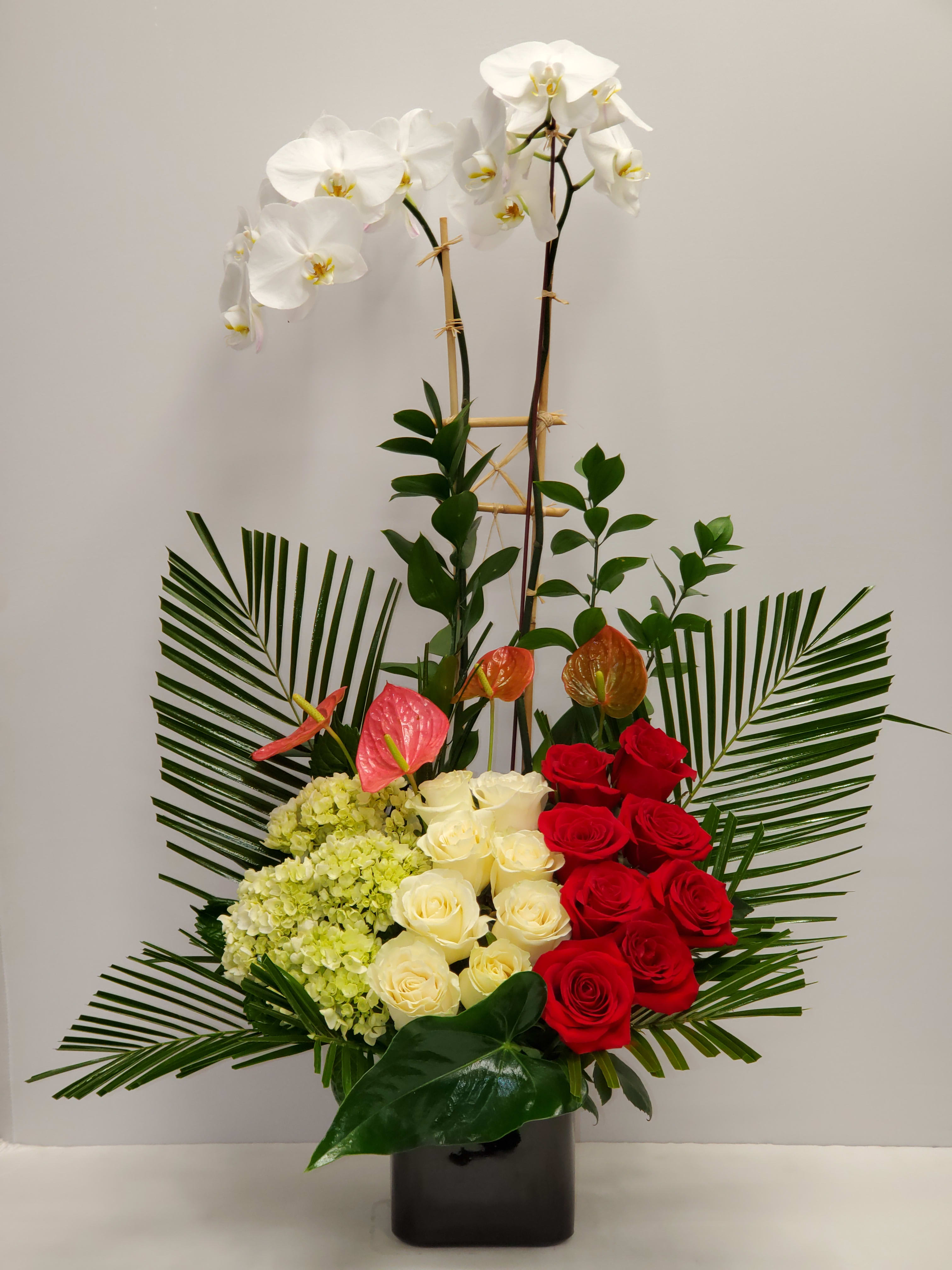 Tropical romance  - Tropical romance is a beautiful romantic arrangement with orchid, roses, hydrangea and beautiful Tropical leaves 