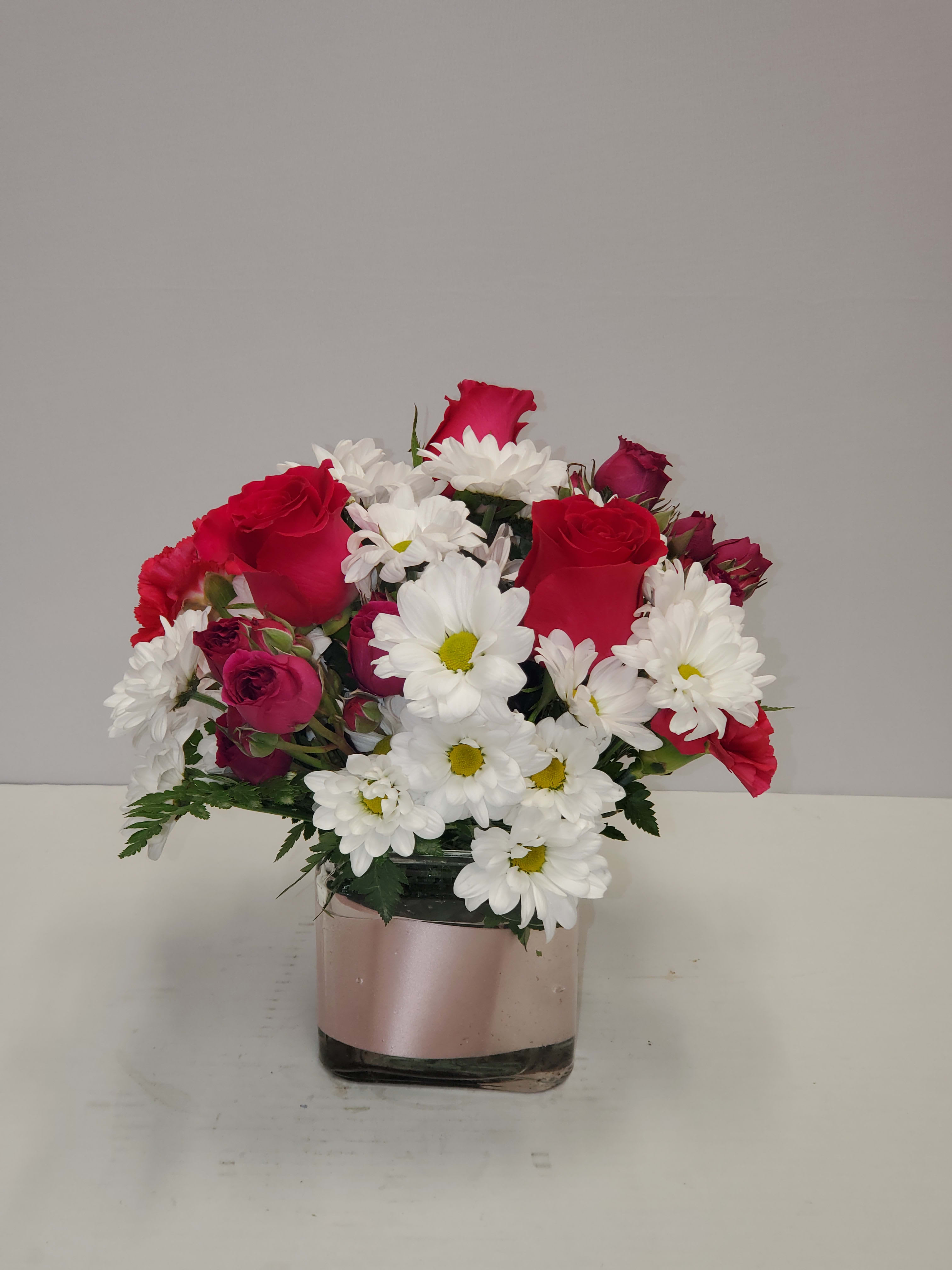 Daisy Me Rollin' by BloomNation - This arrangement contains spray daisies and spray roses. This is a great birthday gift. APPROXIMATE DIMENSIONS: 9"L X 9"W x 9"H