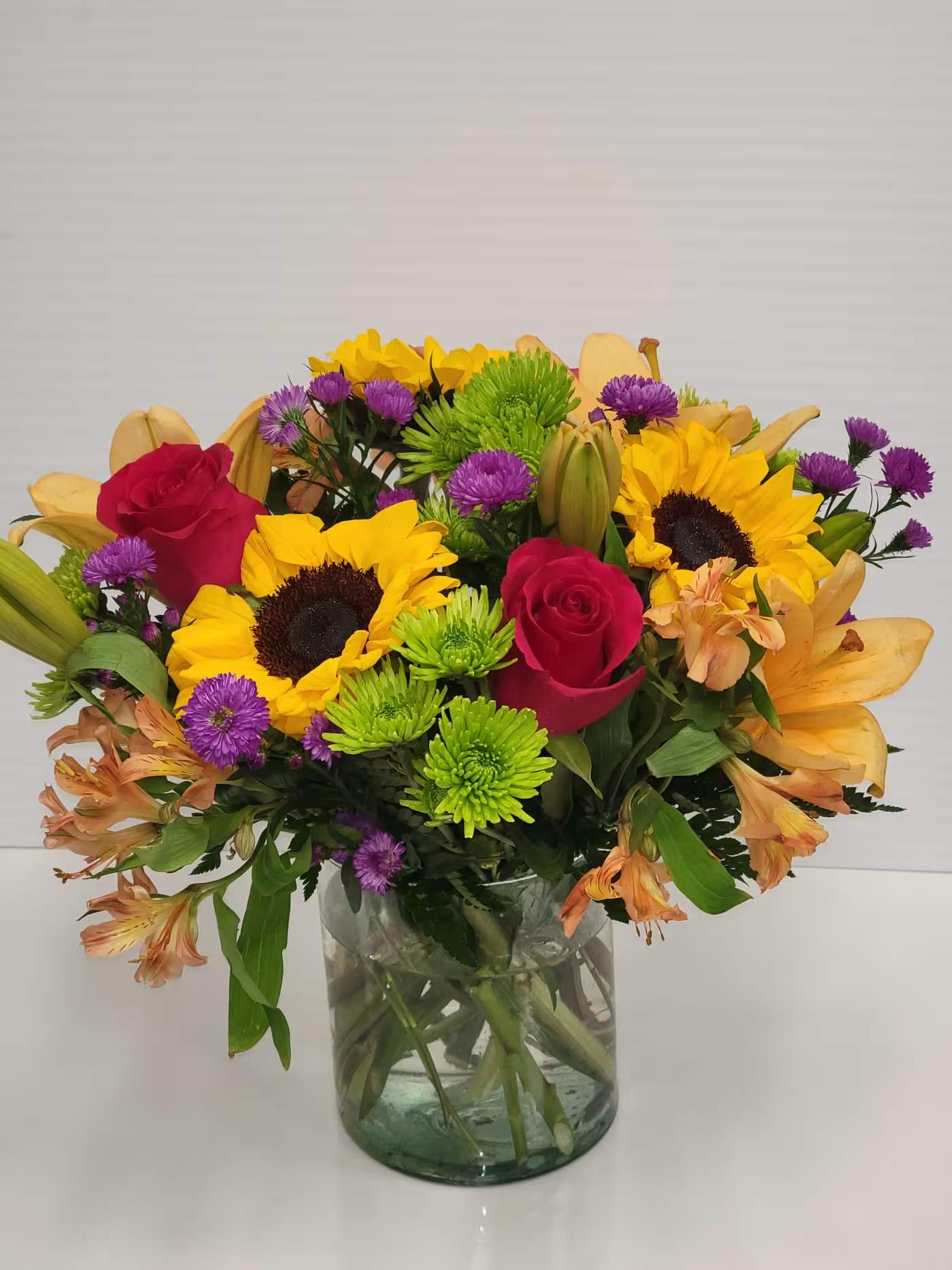 Bright Embrace  - Bright Embrace is in nice low cylinder vase with Bright color flowers for any occasion 