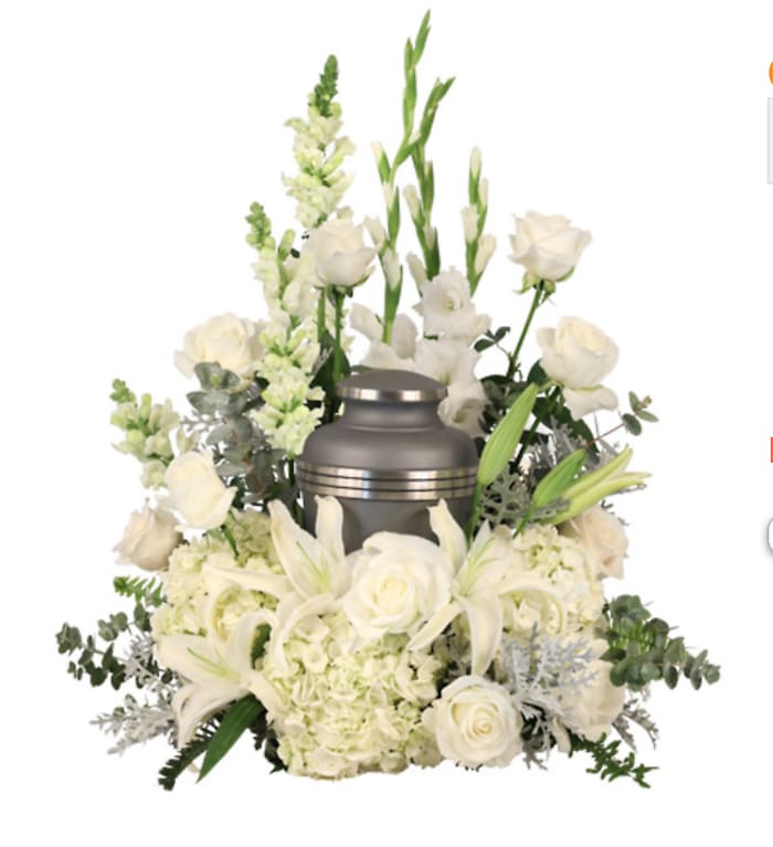 White floral funeral arrangement with a silver urn centerpiece