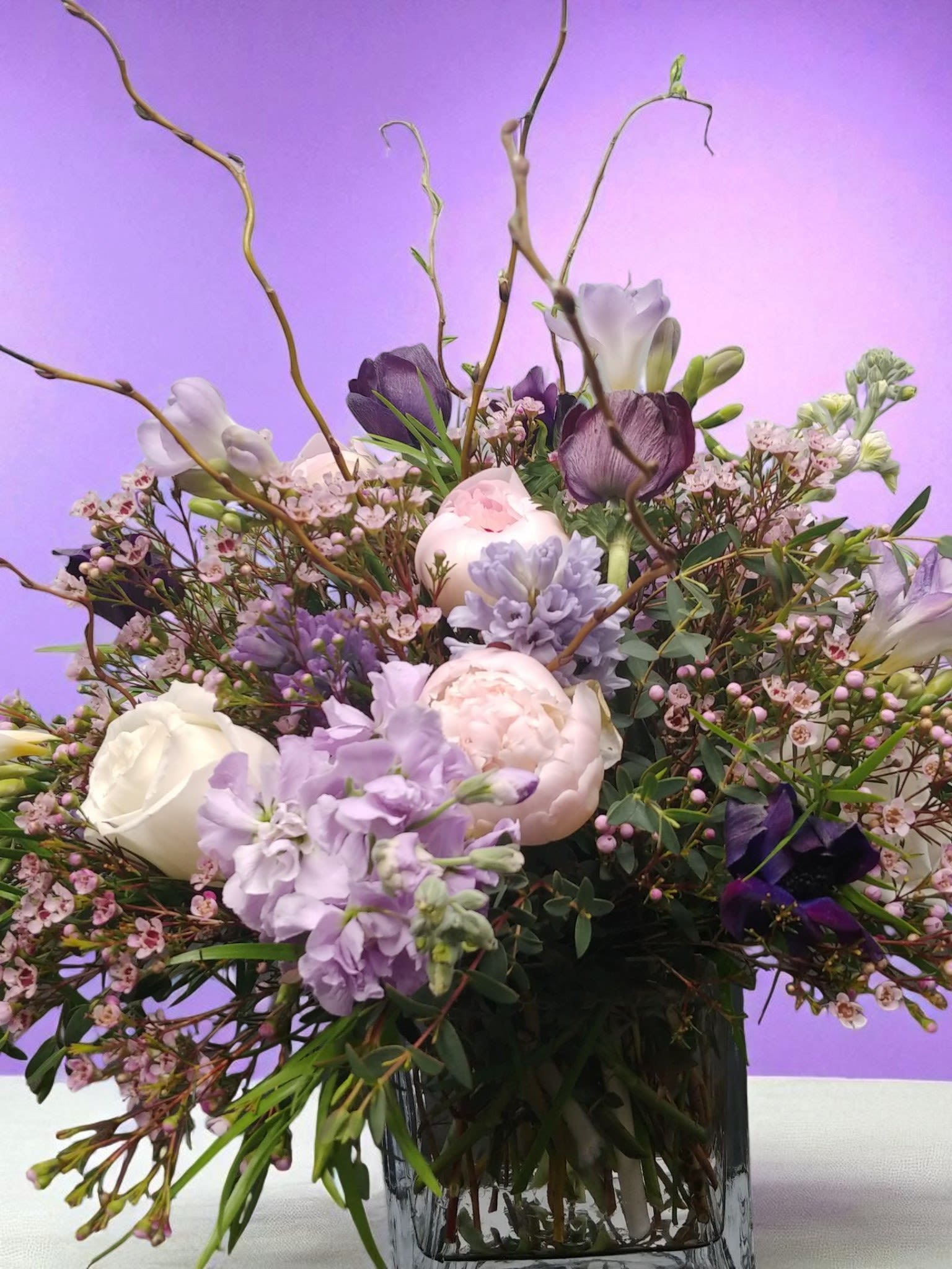 Lavender and white floral arrangement in a clear glass vase