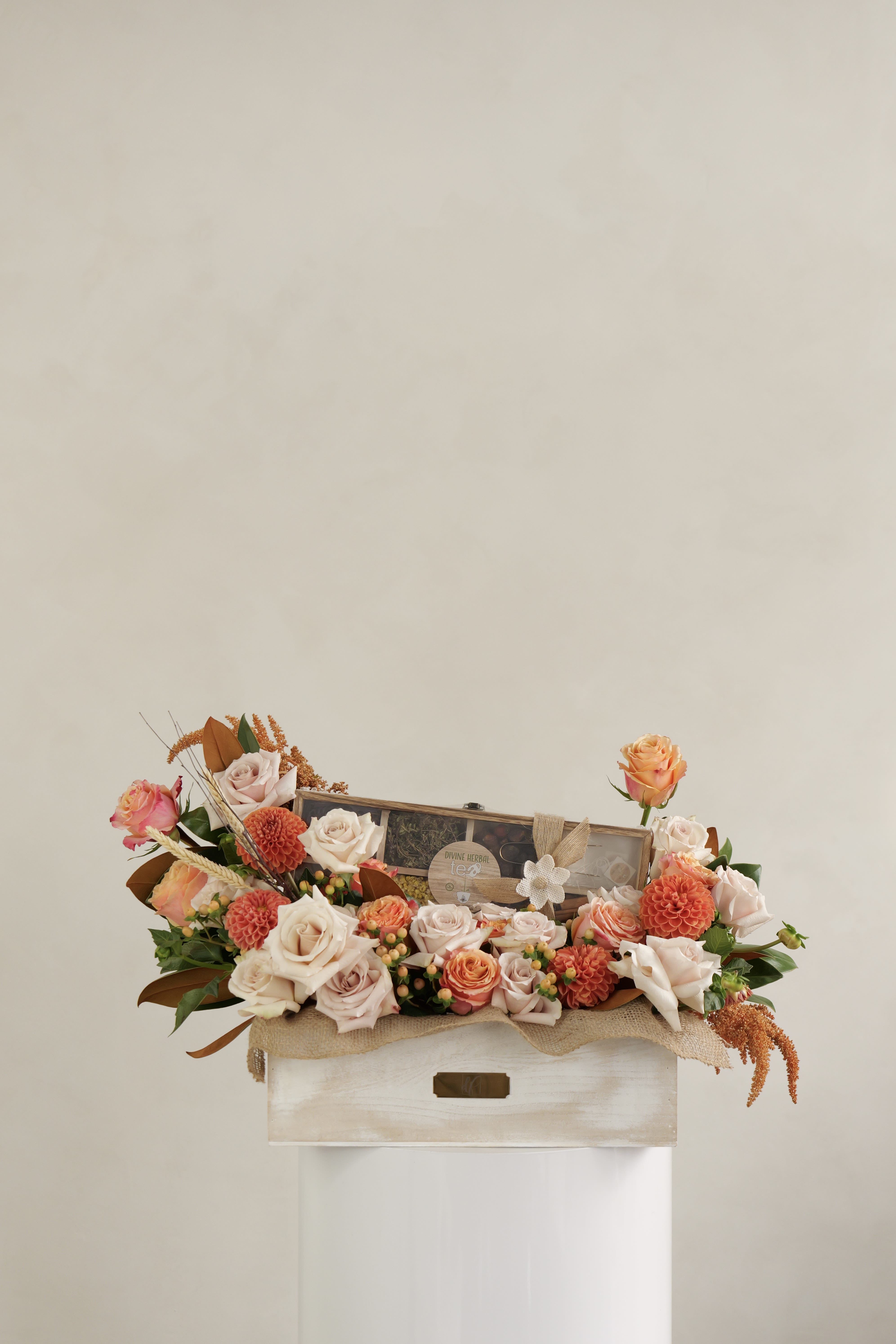 Mixed rose arrangement in a wooden box with a tea gift set
