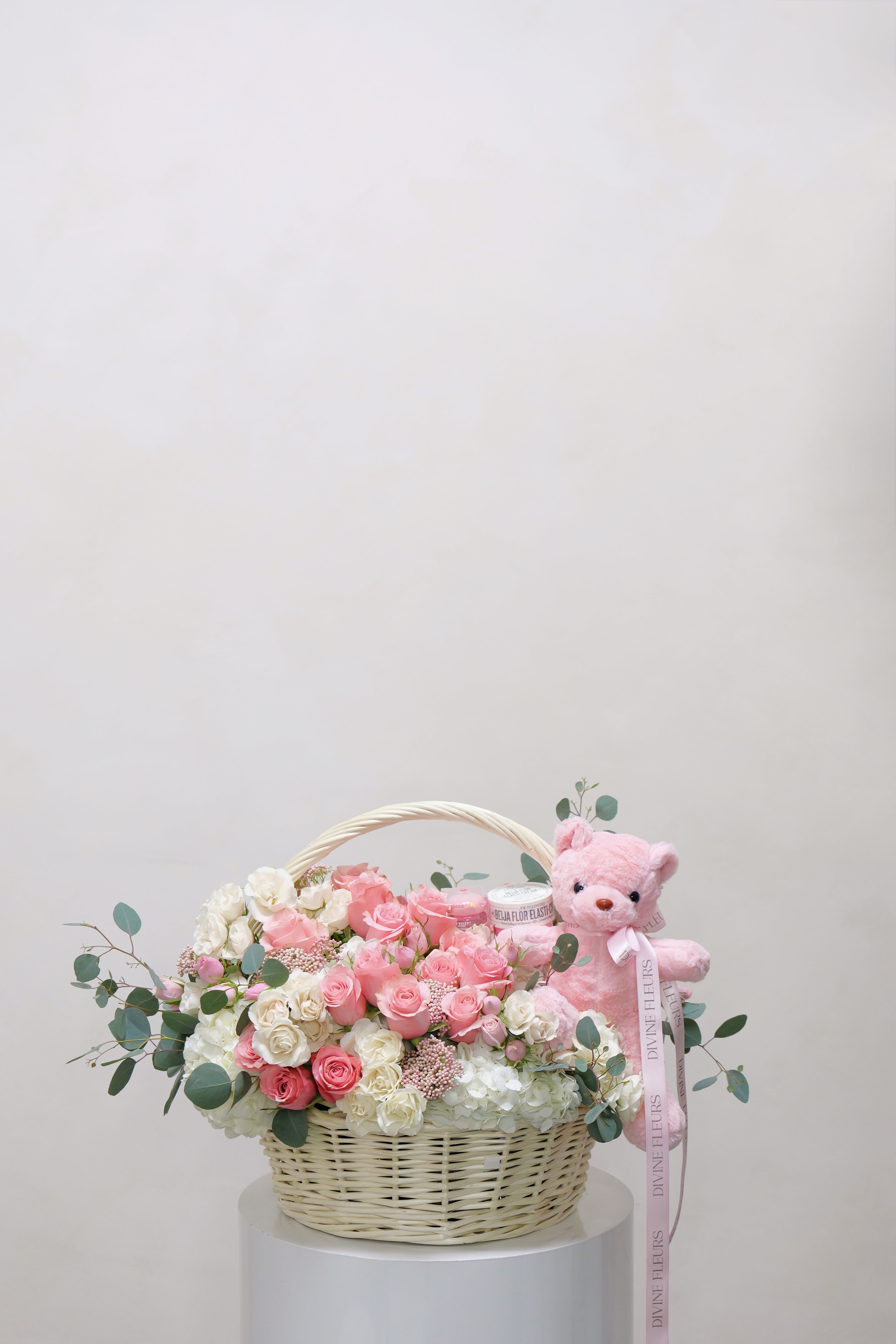 Pink and white rose basket with a pink teddy bear