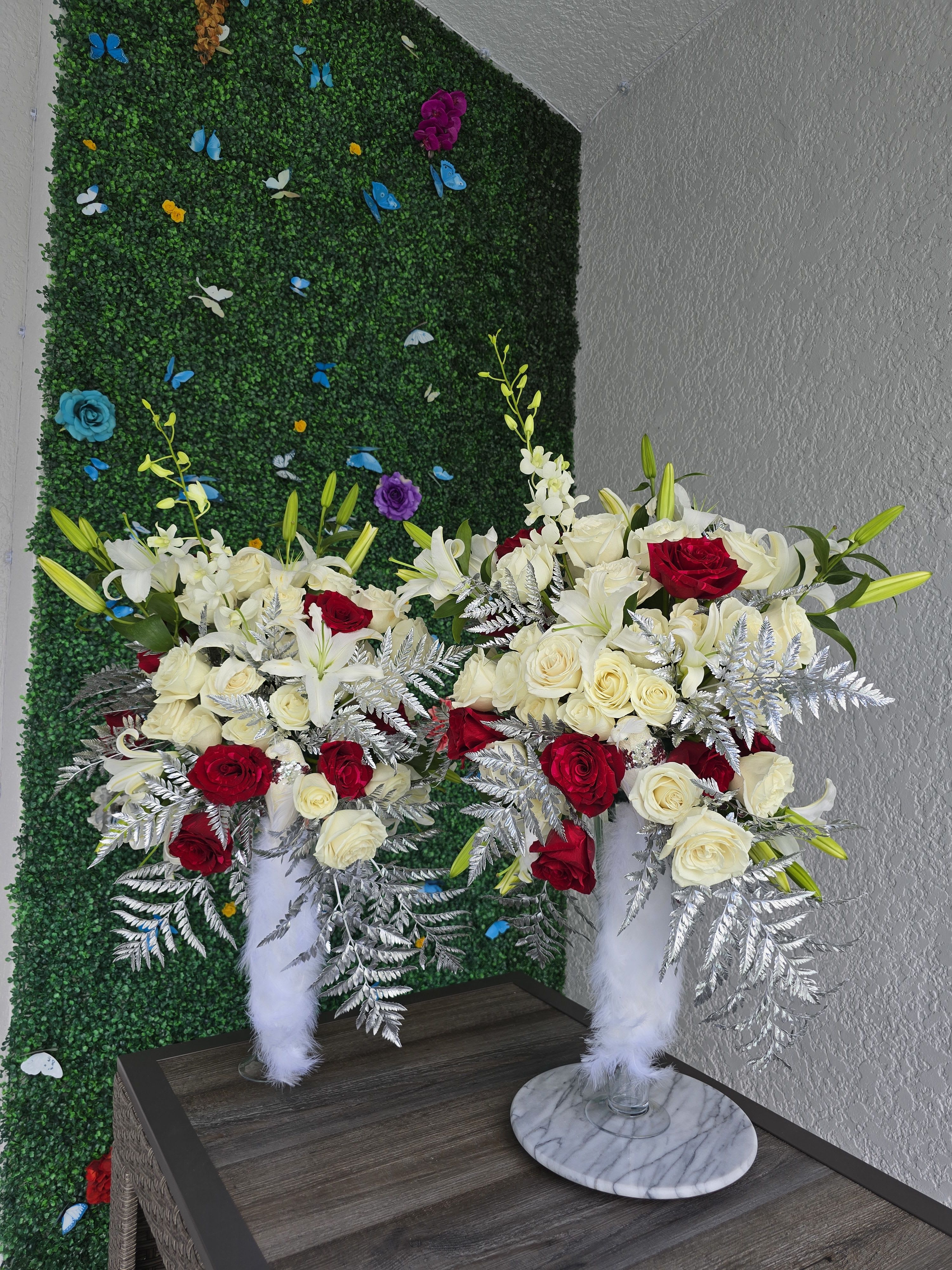 Elegant Touch  - Elegant Floral Arrangements on Crystal Pedestals  **PER PIECE** Refined, luxurious, and made to impress — our floral arrangements on crystal pedestals are designed to elevate any space or event with timeless elegance and sophistication.  Standing tall and graceful, these arrangements combine premium blooms with the clean, modern beauty of crystal bases. Perfect for grand entrances, upscale events, corporate spaces, or stylish home decor, they add height, presence, and a touch of glamor wherever they’re placed.   Each piece is customized to your color palette and floral preferences, ensuring that every arrangement feels unique and unforgettable.   Delivery and setup available  Where elegance stands tall — floral art on crystal display 