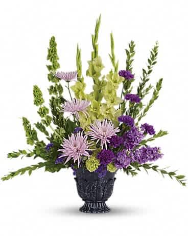 Purple and green floral arrangement in a black urn vase