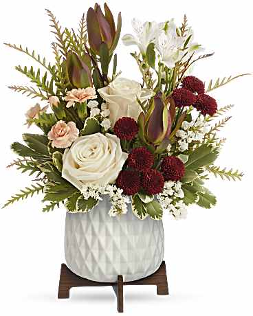 Floral arrangement with white roses, lilies, and burgundy blooms in a white vase