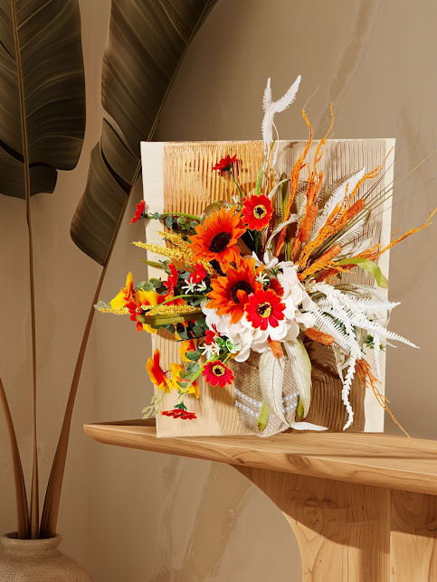 Bright orange and red floral arrangement with white accents in a decorative display