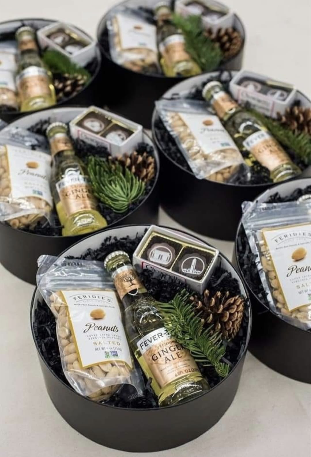 Team Holiday Surprise - A bottle of wine, with a jar of pistachios, walnuts and mixed seeds, finely decorated in a box with Christmas touches with a personalized gift from the company.