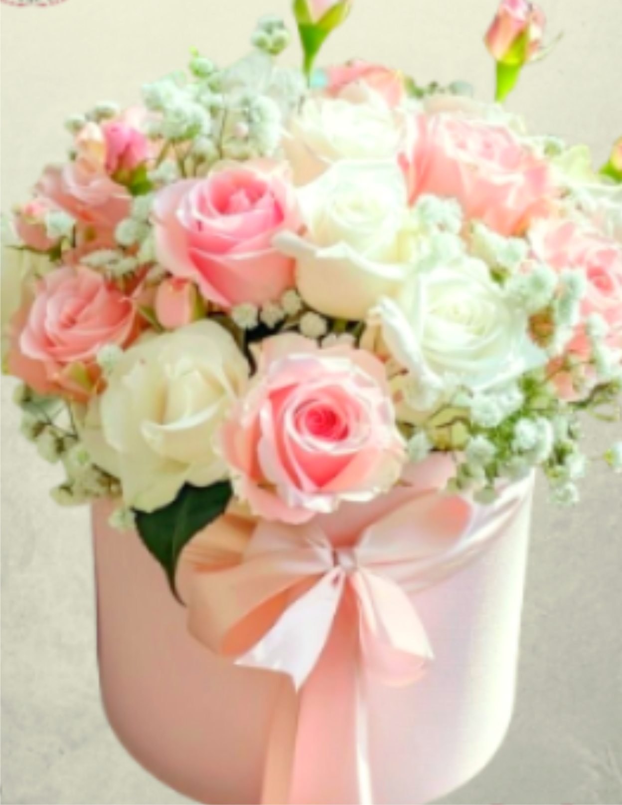 Pink and white roses in a pastel hatbox with a ribbon bow