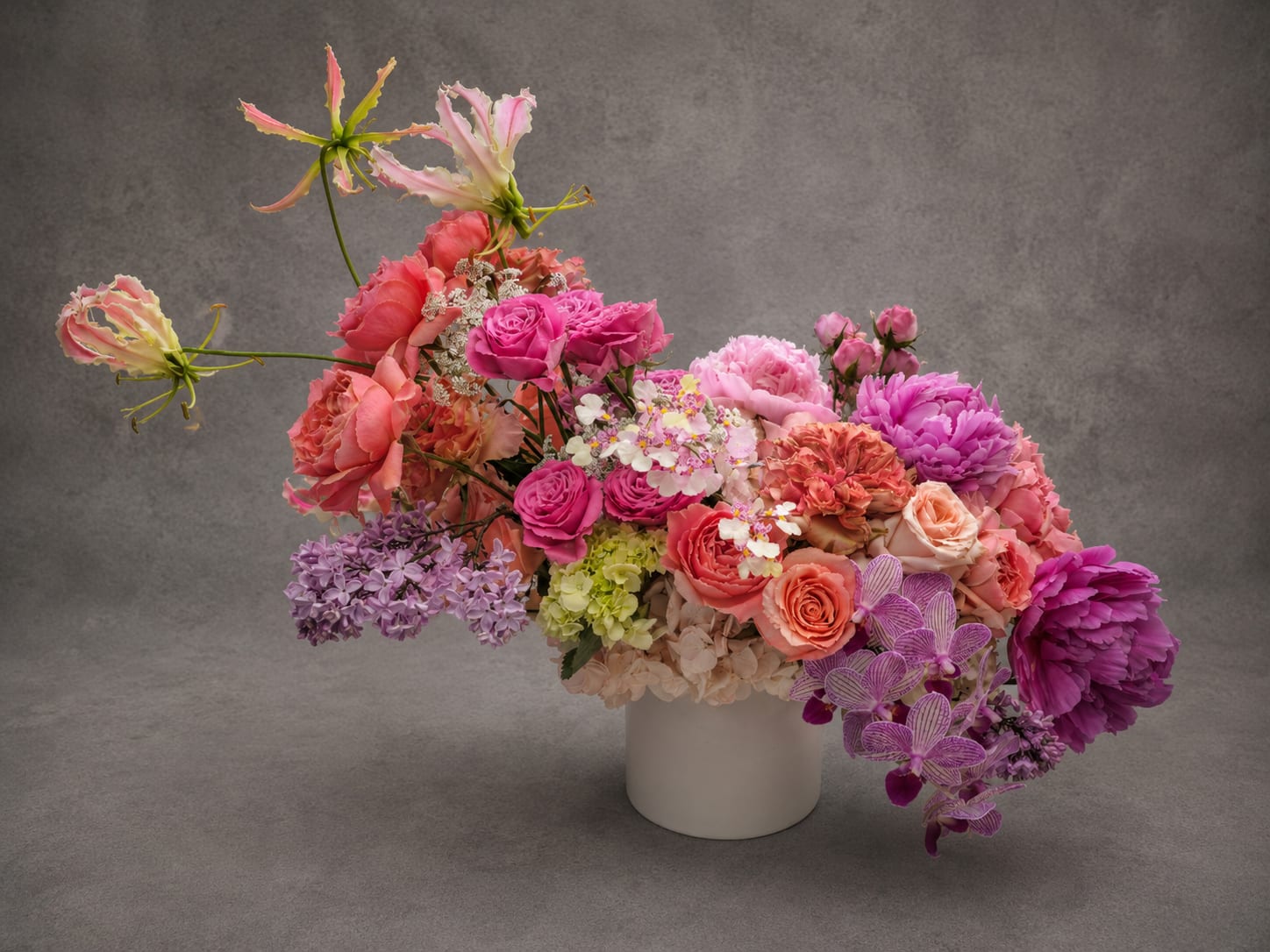 Daphne - Daphne celebrates movement, color, and contrast through a curated collection of seasonal blooms. Sculptural stems, layered textures, and luminous shades of blush, coral, and pink create a composition that feels both playful and refined.