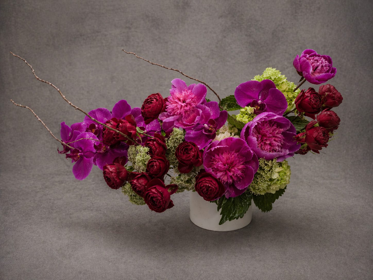 Serafina - Valentina is a study in drama and restraint. Saturated tones of crimson, magenta, and violet are balanced by sculptural branches and luminous seasonal blooms, resulting in a composition that is bold, architectural, and undeniably elegant.