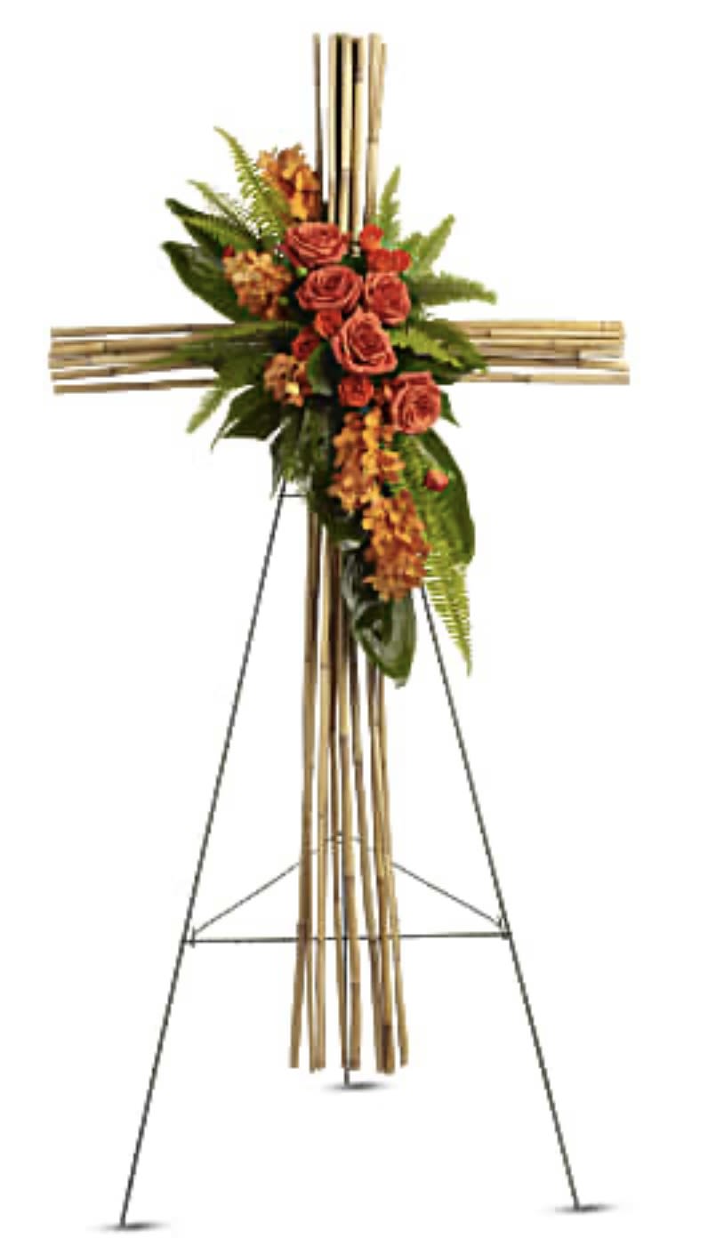Floral cross on a stand with orange roses and greenery