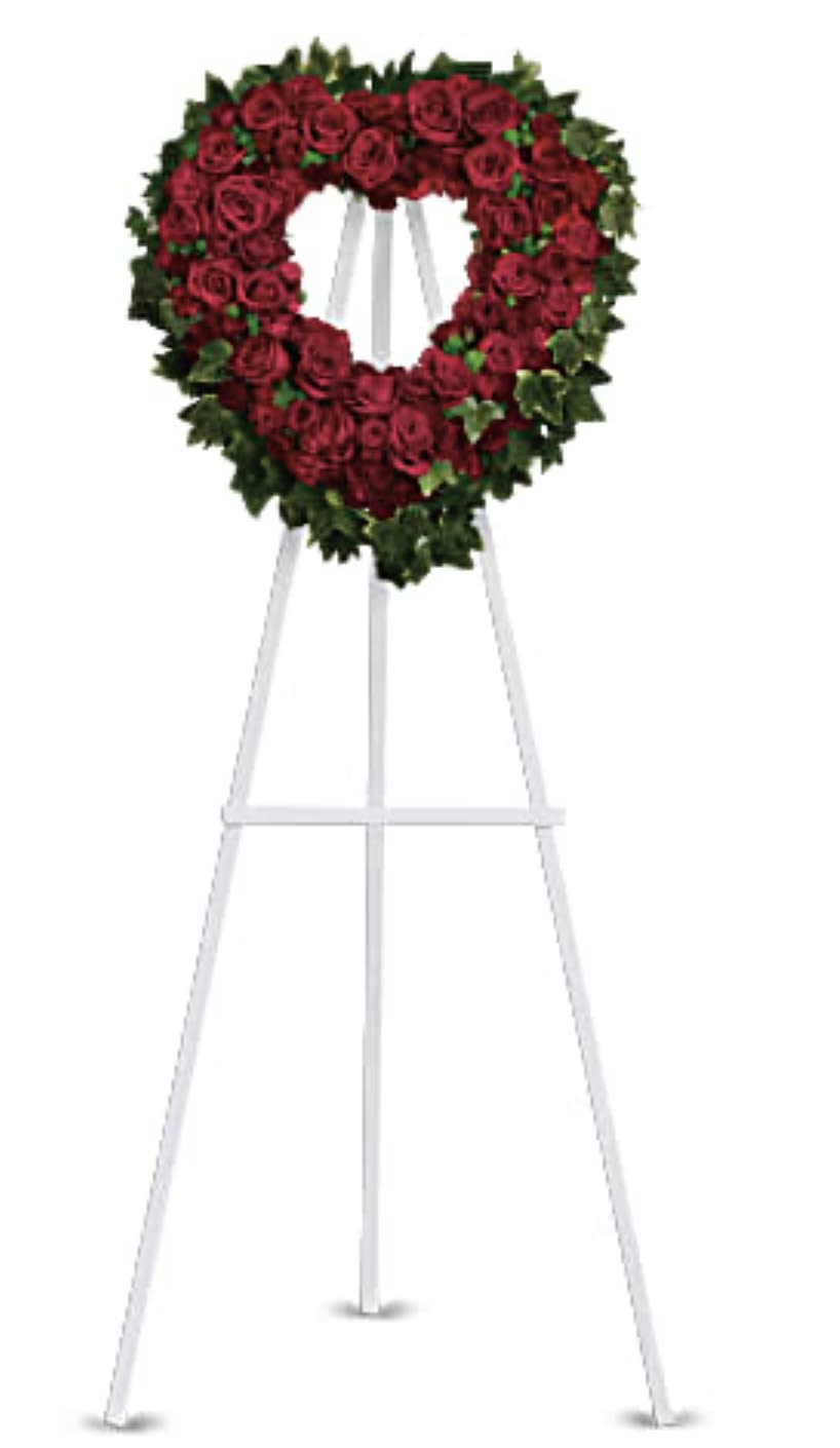 Heart-shaped red rose wreath on a white easel