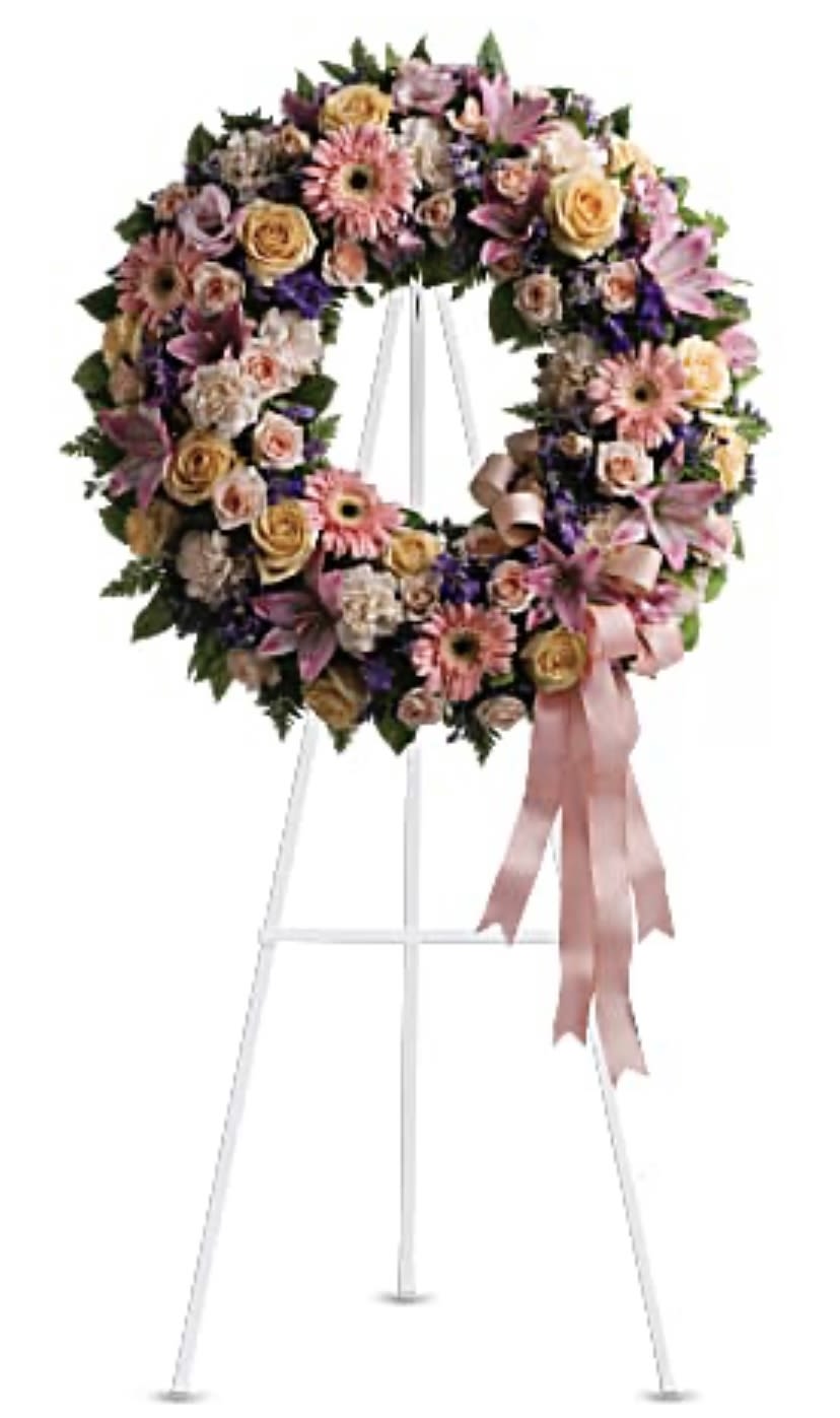 Floral wreath on a white easel with pink ribbon