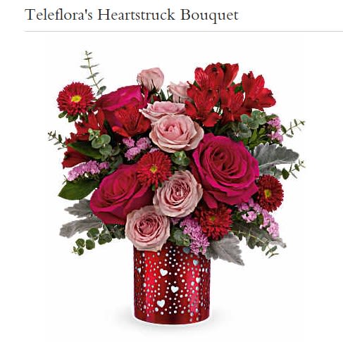 Bouquet of red and pink roses in a red heart-patterned vase