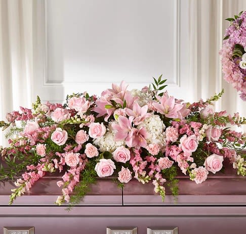 Pink floral casket spray with roses and lilies